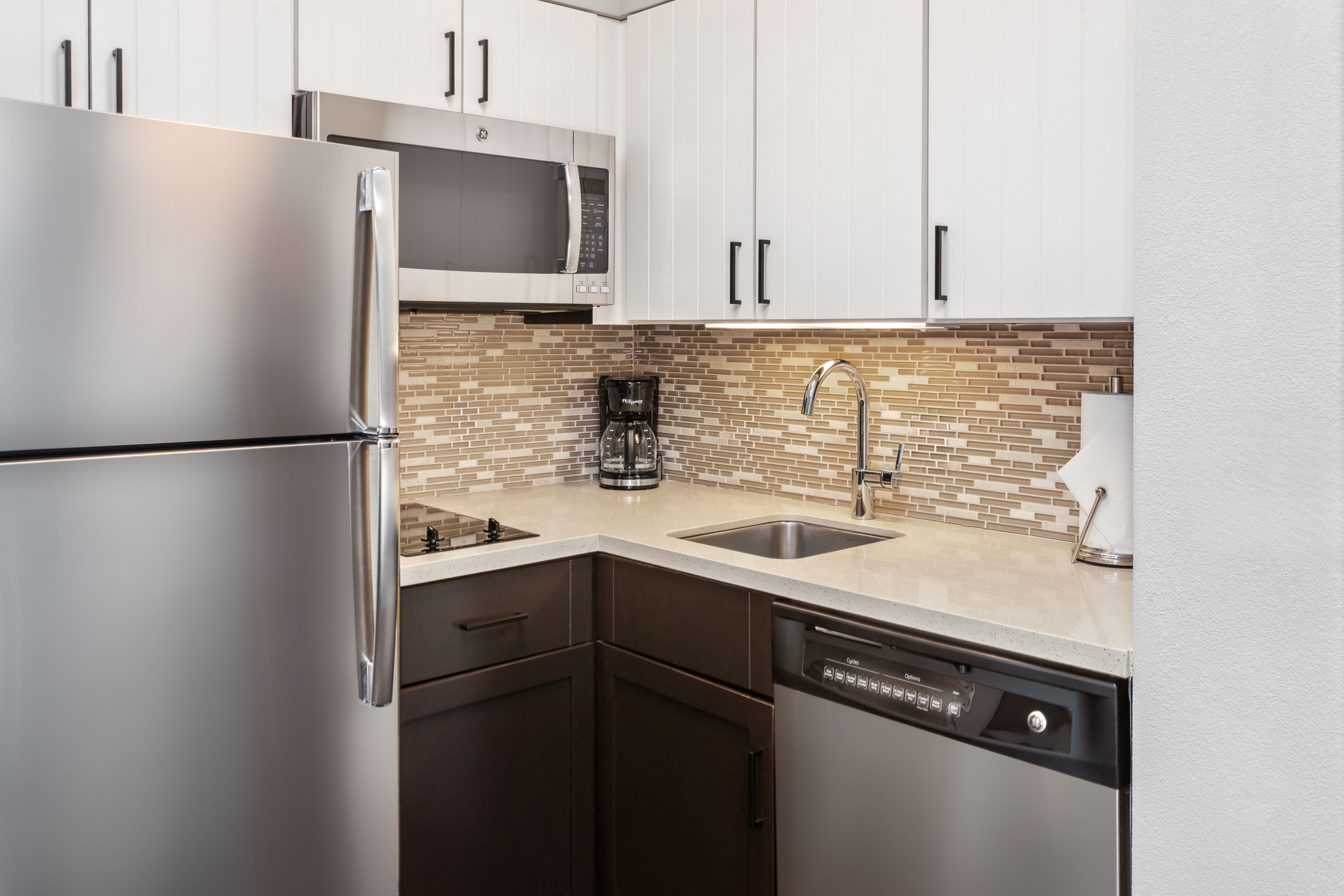 image Modern kitchen equipped with stainless appliances and sleek countertops.