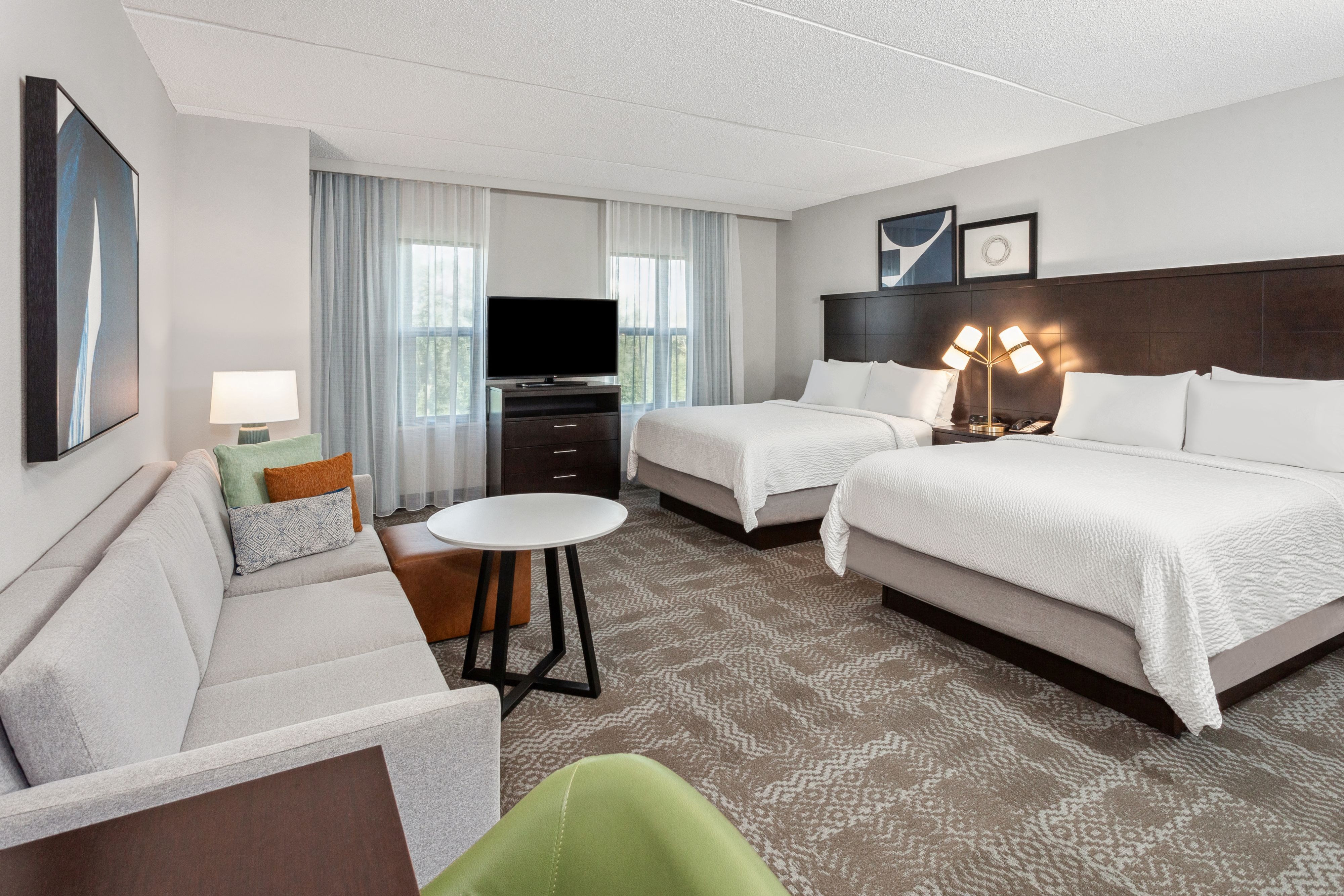 image Inviting suite featuring two beds and ample natural light.