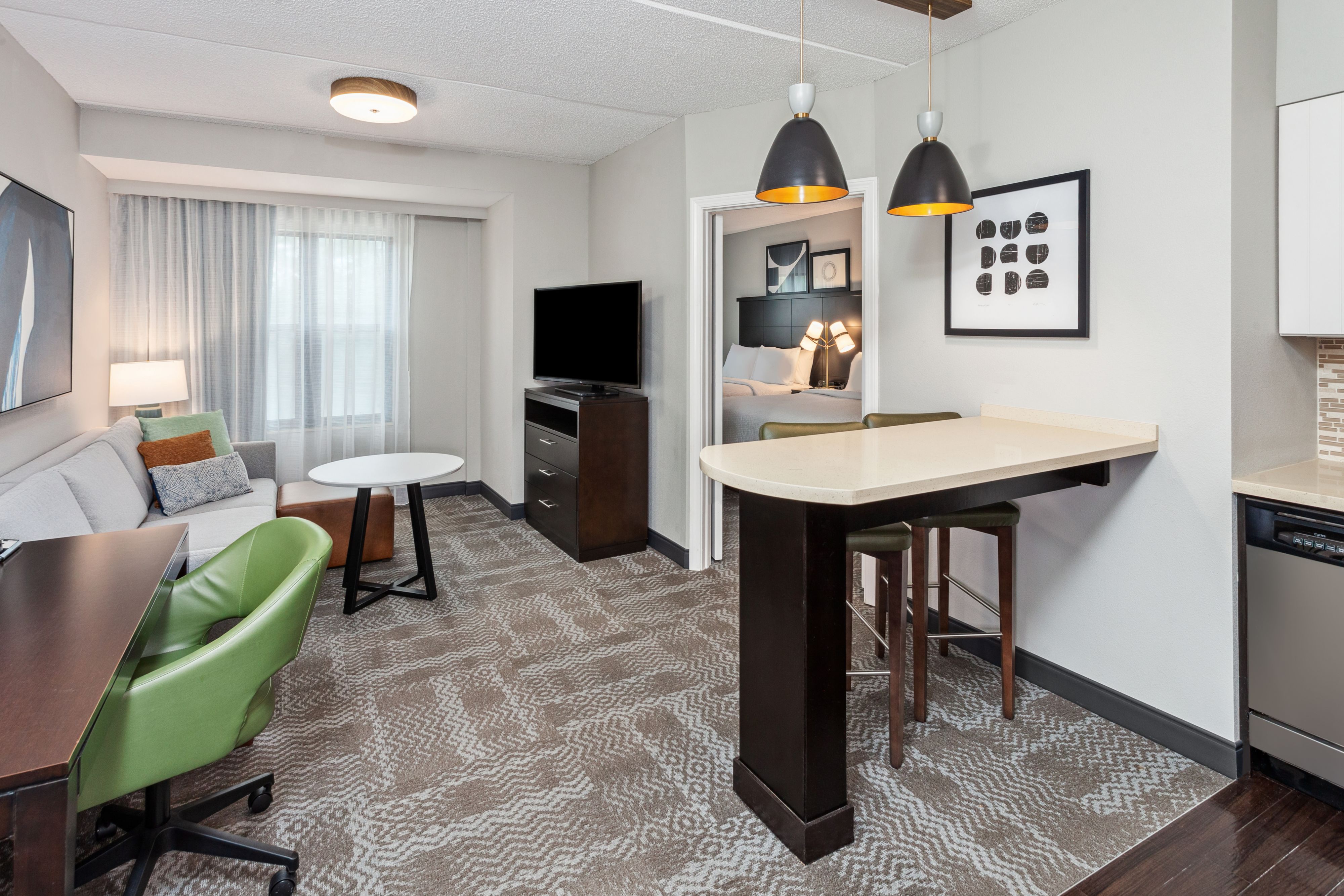 image Spacious suite showcasing a living area and kitchenette.
