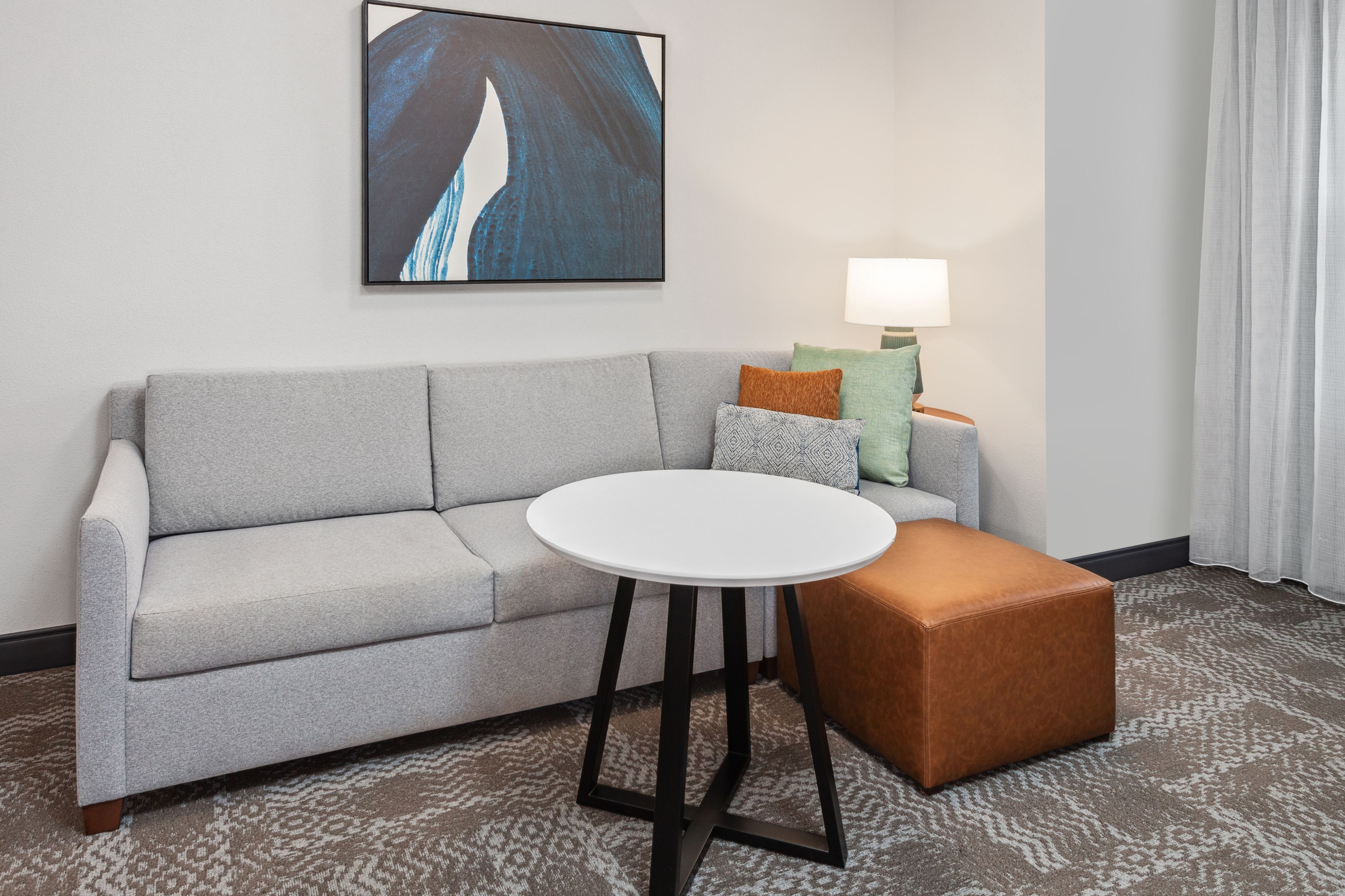 image Inviting living area with a sofa, coffee table, and artwork.