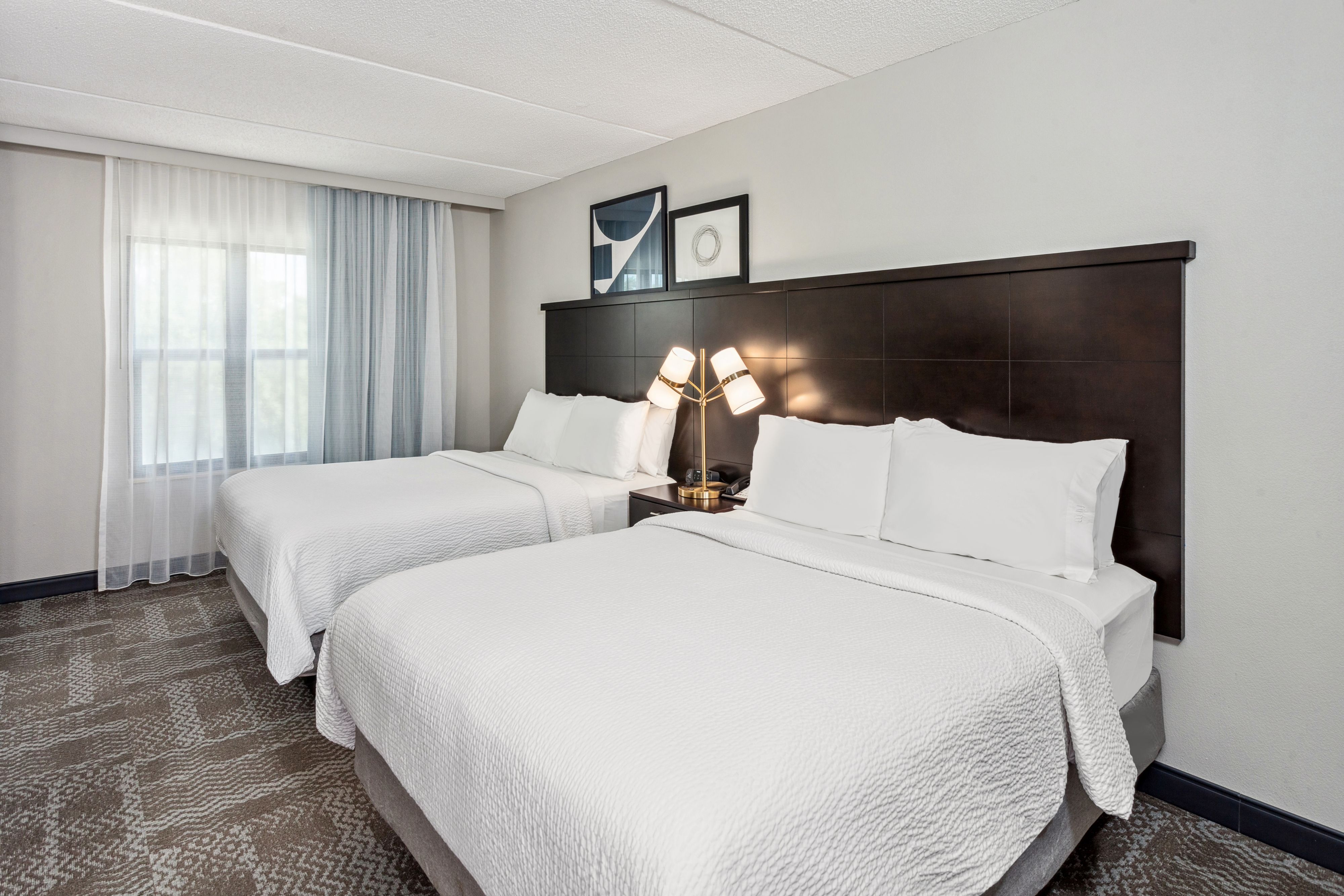 image Inviting room with two queen beds and window light.