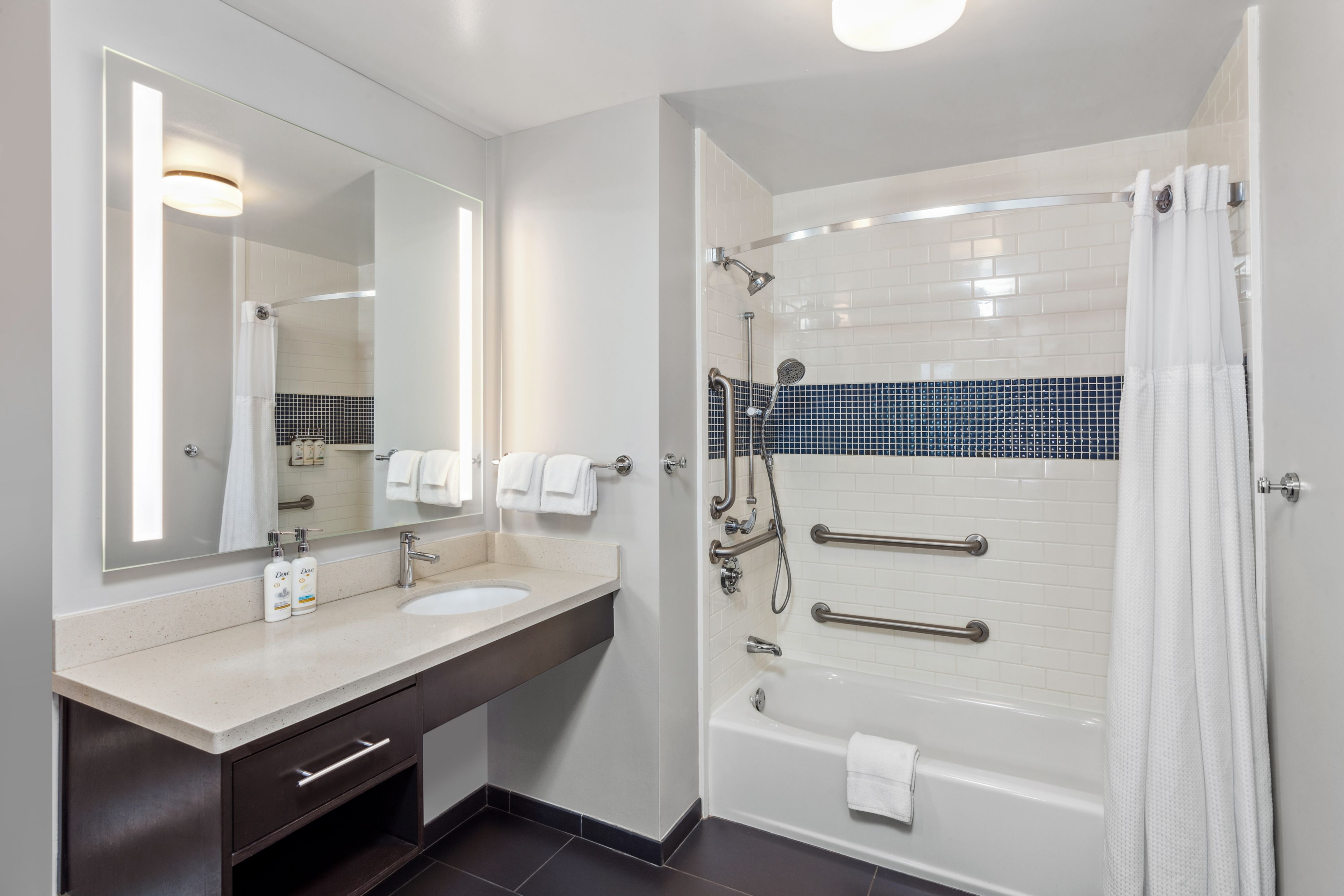 image Bright bathroom with a spacious shower and illuminated mirror.