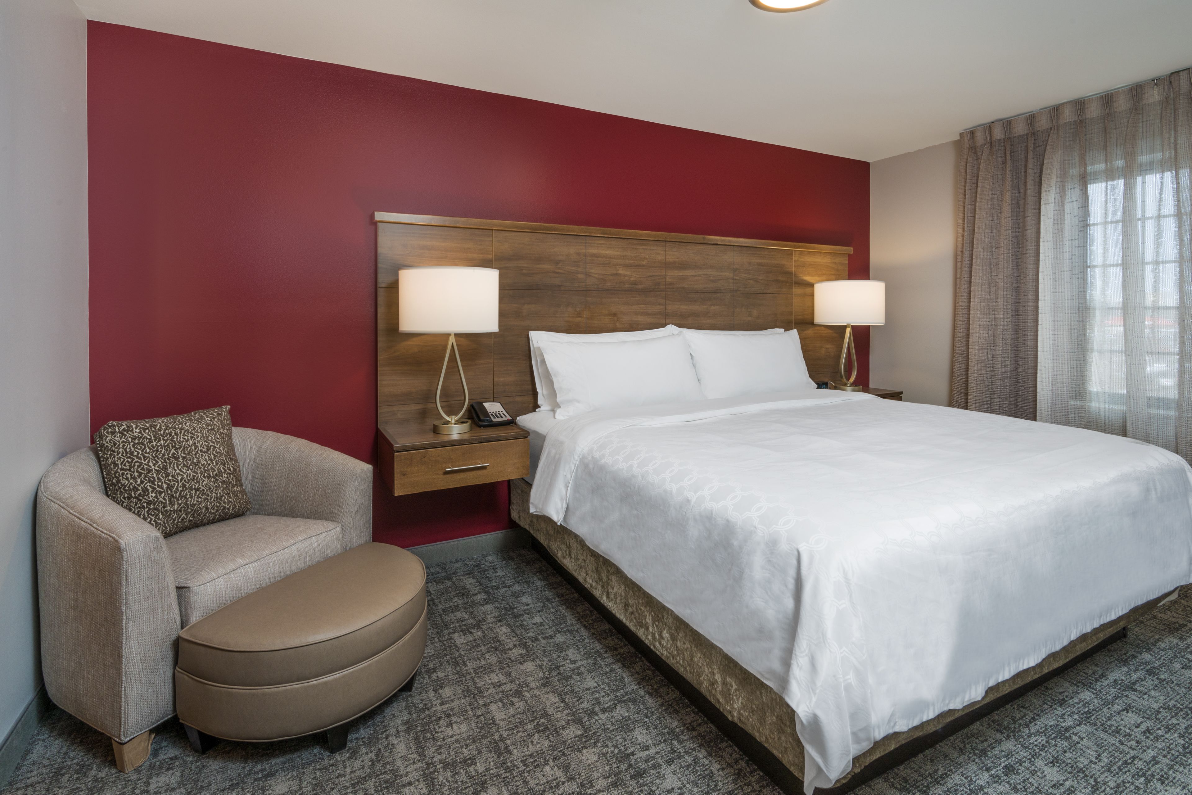 image Bedroom with king bed, lamps, and armchair.