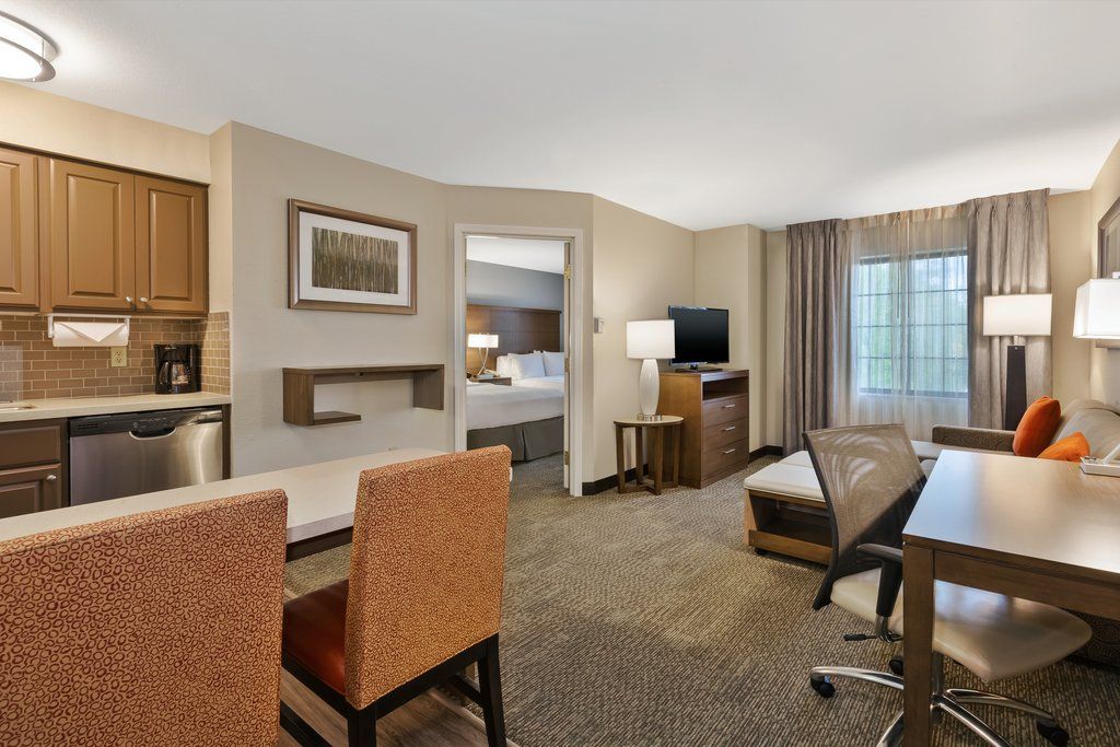 image Relax in your stylish living area, featuring a cozy workstation and a well-equipped kitchen for all your meal prep