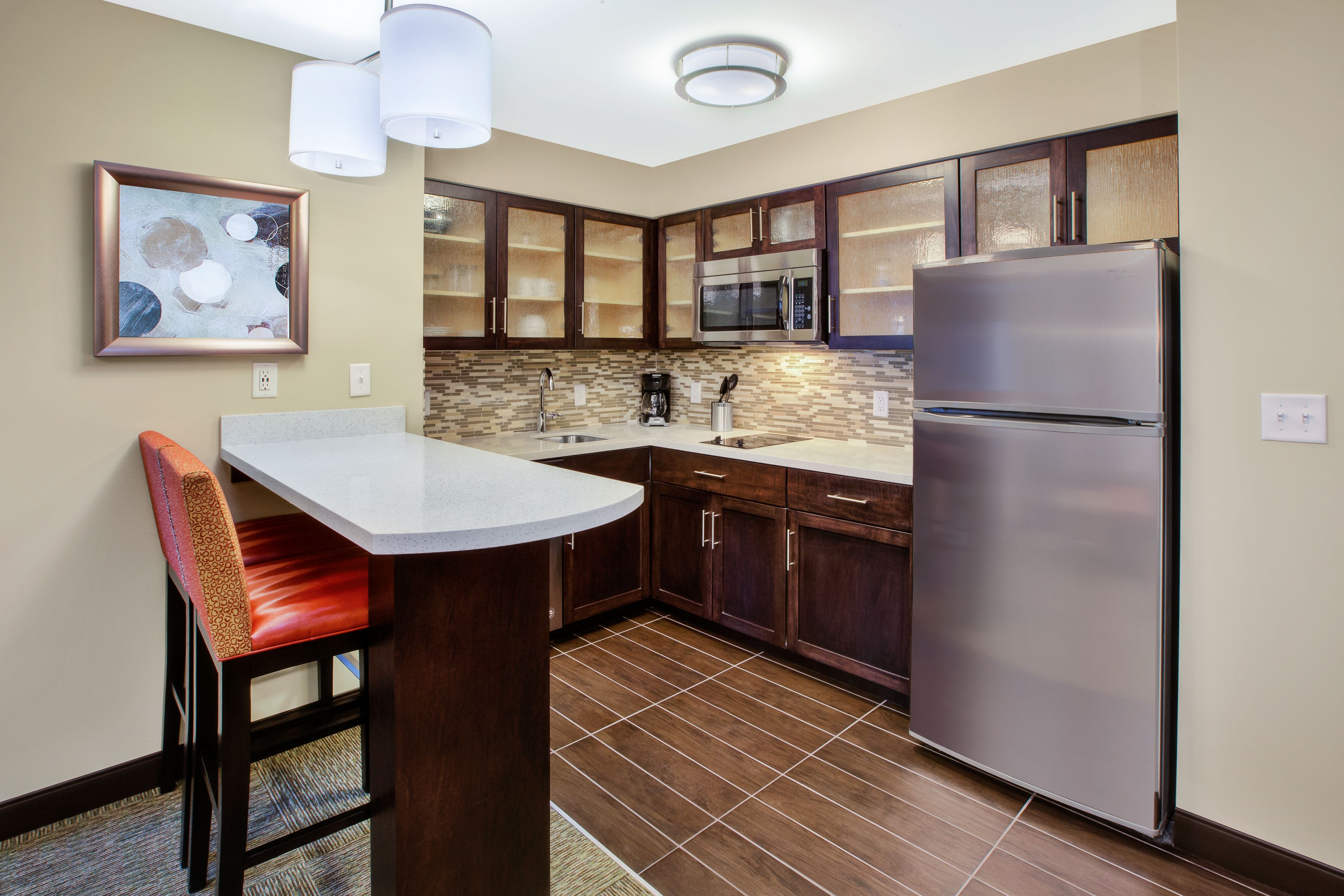 image Fully equipped kitchen with stainless steel appliances and bar seating.