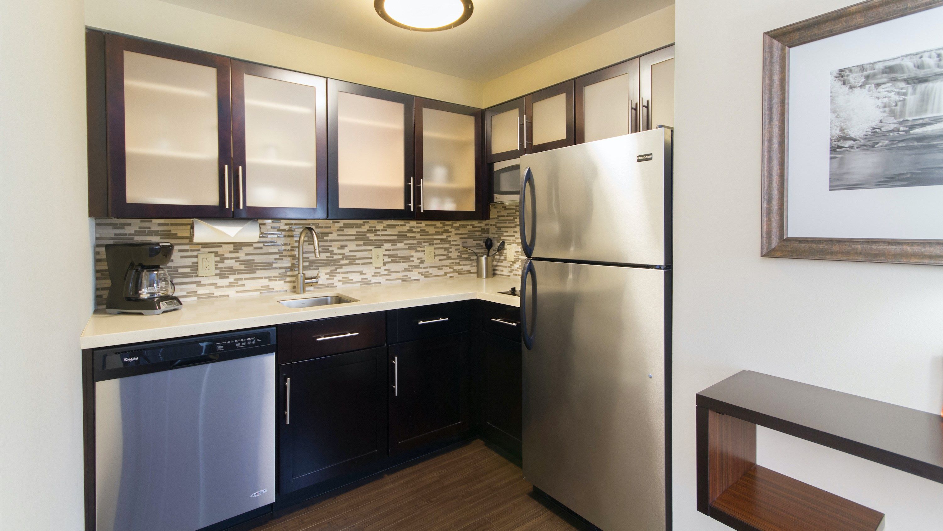 image Full kitchen with dark cabinetry, tile backsplash, and everything you need to cook a real meal