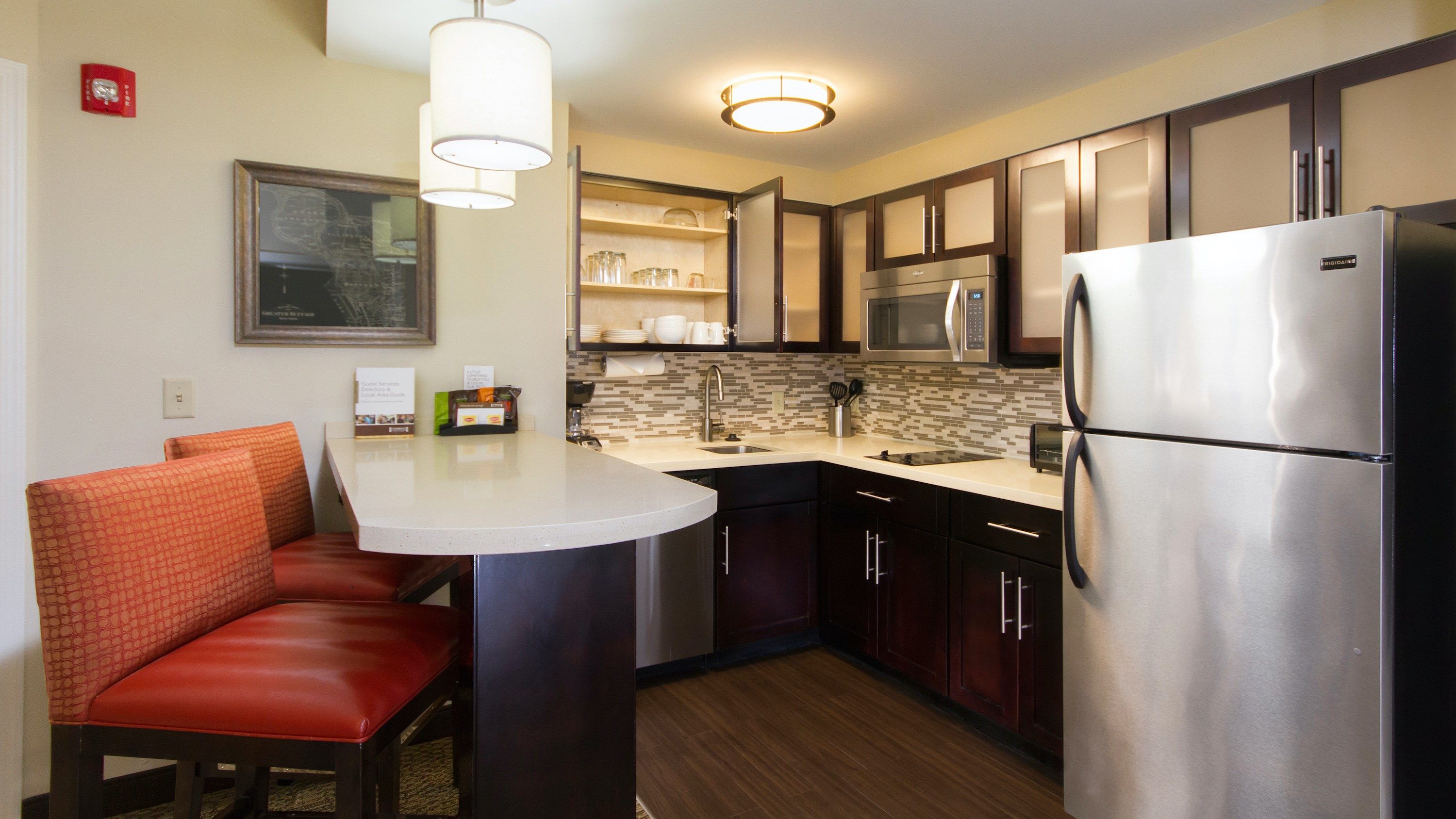 image Full kitchen with dark wood cabinetry, stovetop, microwave, and coffee maker ready to go