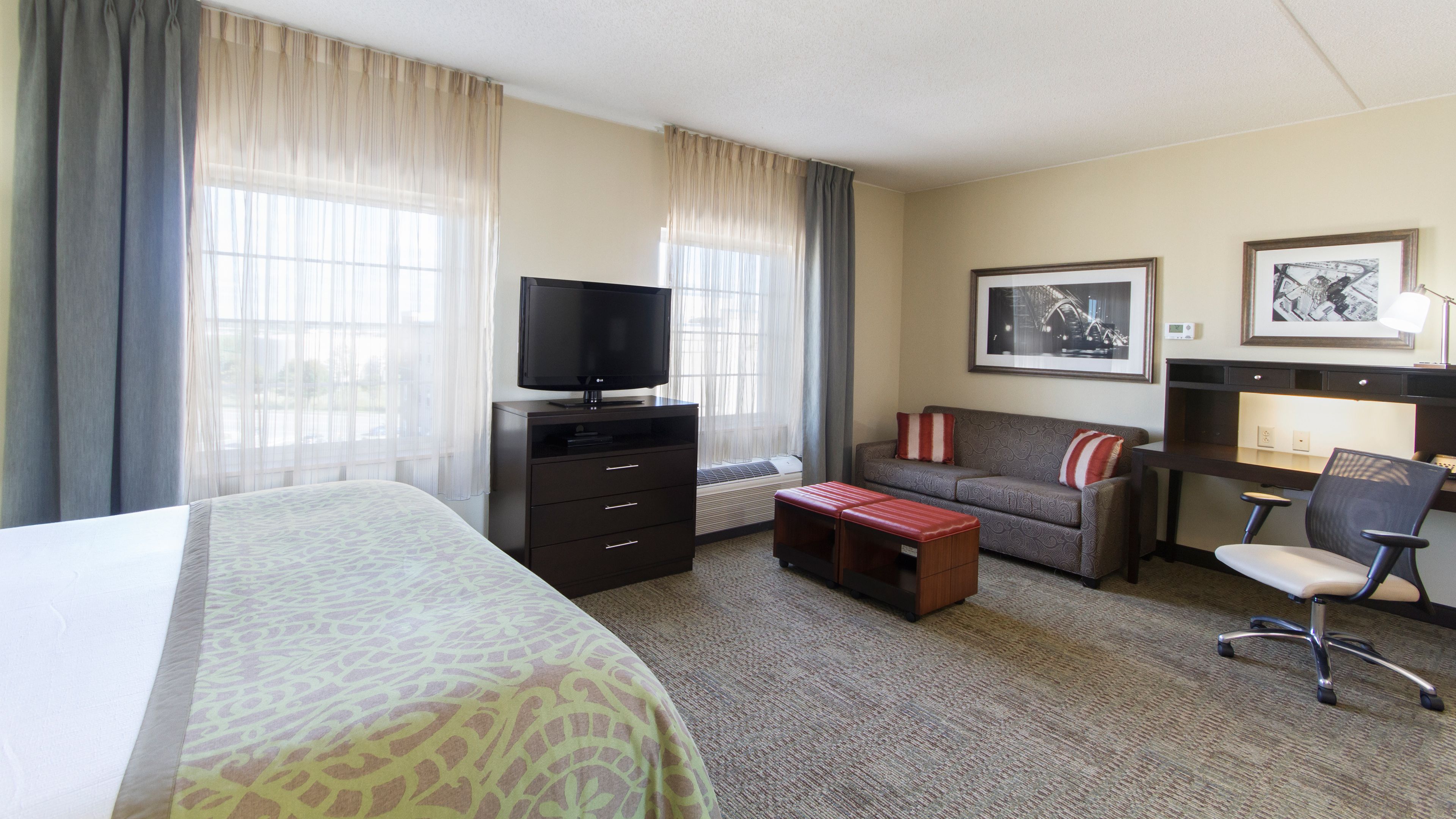 image King bed with white linens and sheer curtains filtering the morning light