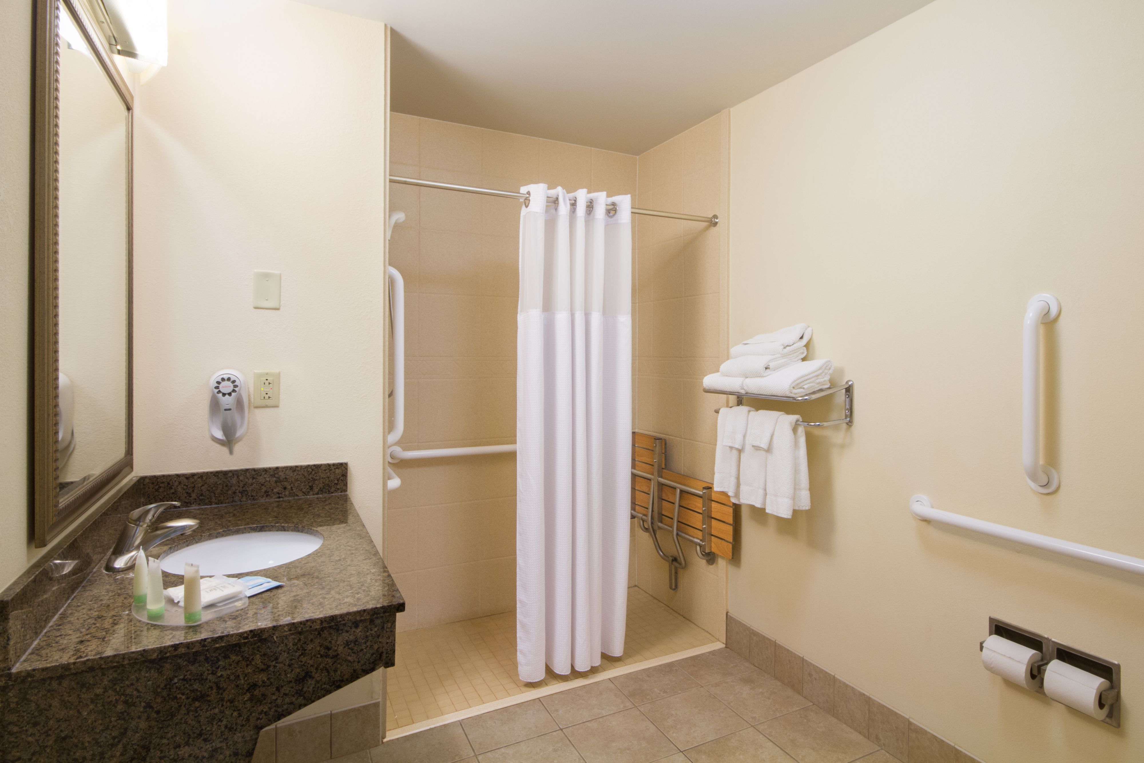 image Accessible bathroom with safety features and ample towels.