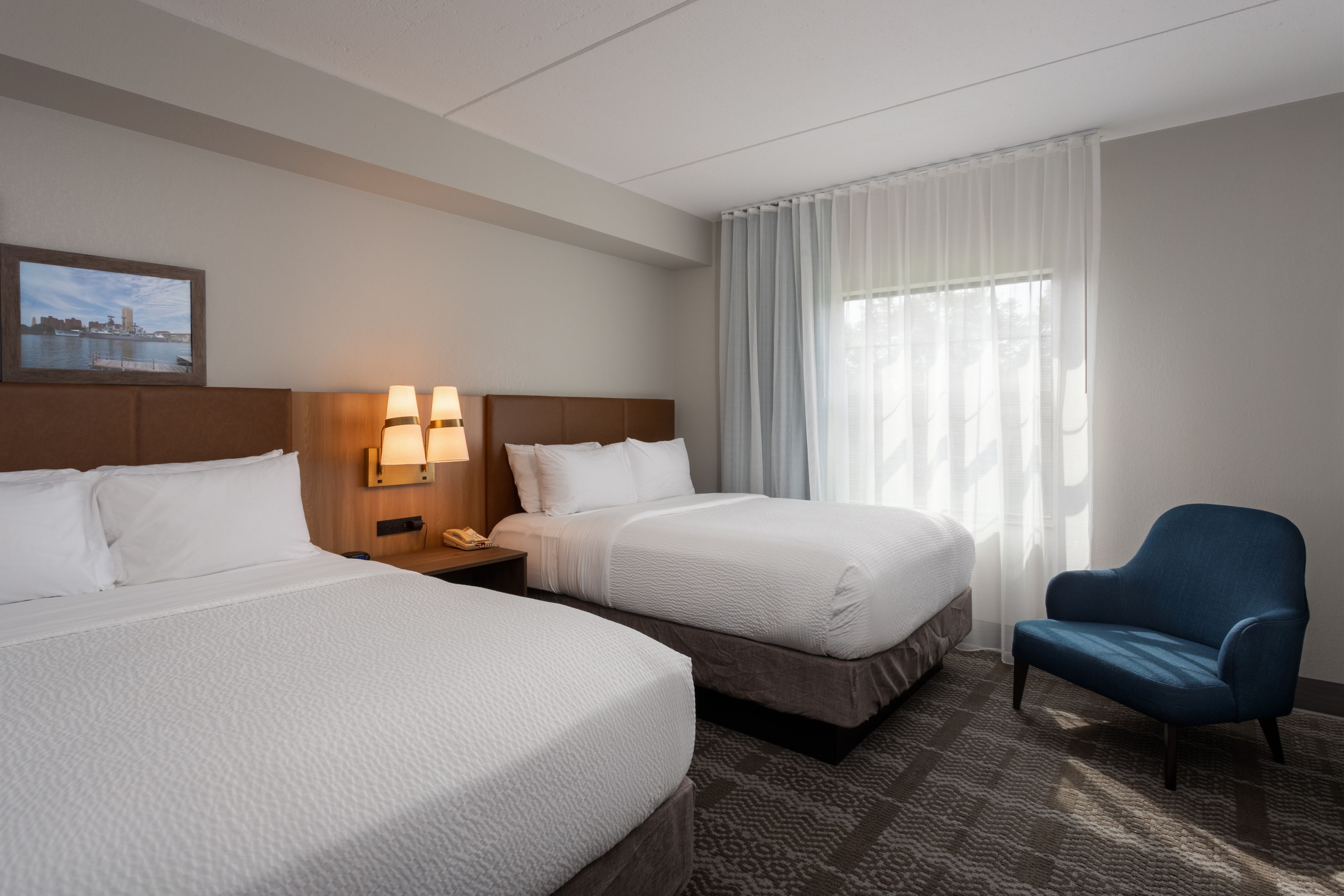 image Spacious bedroom with two double beds and comfortable seating.