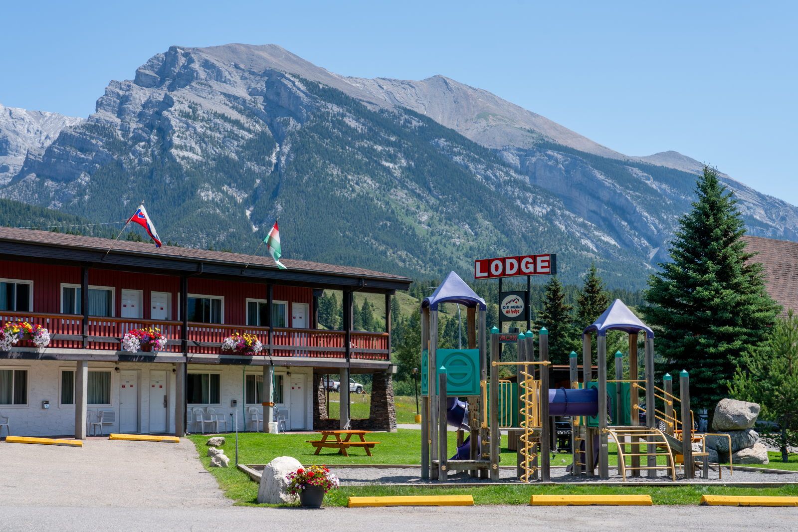 image Outdoor common area with a kids' playground, set against the tree-lined mountain landscape