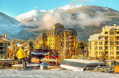 Mountain village alive with vibrant energy, nestled beneath snow-dusted peaks.