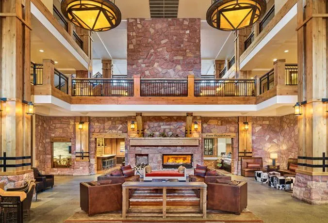 image The grand lobby, featuring soaring ceilings and rich wooden accents, invites guests to unwind by the stunning stone fireplace, blending rustic charm with upscale comfort.