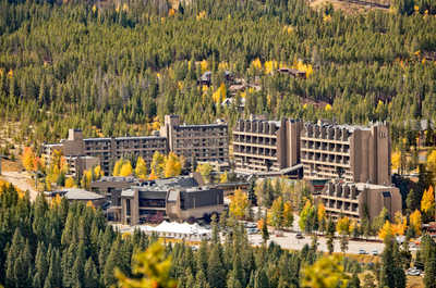 Aerial view of the resort nestled amidst lush forests and rolling hills, epitomizing serene luxury and natural grandeur.