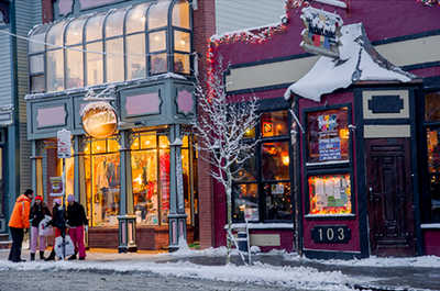 Vibrant life and local commerce on Main Street amidst a snowy day.