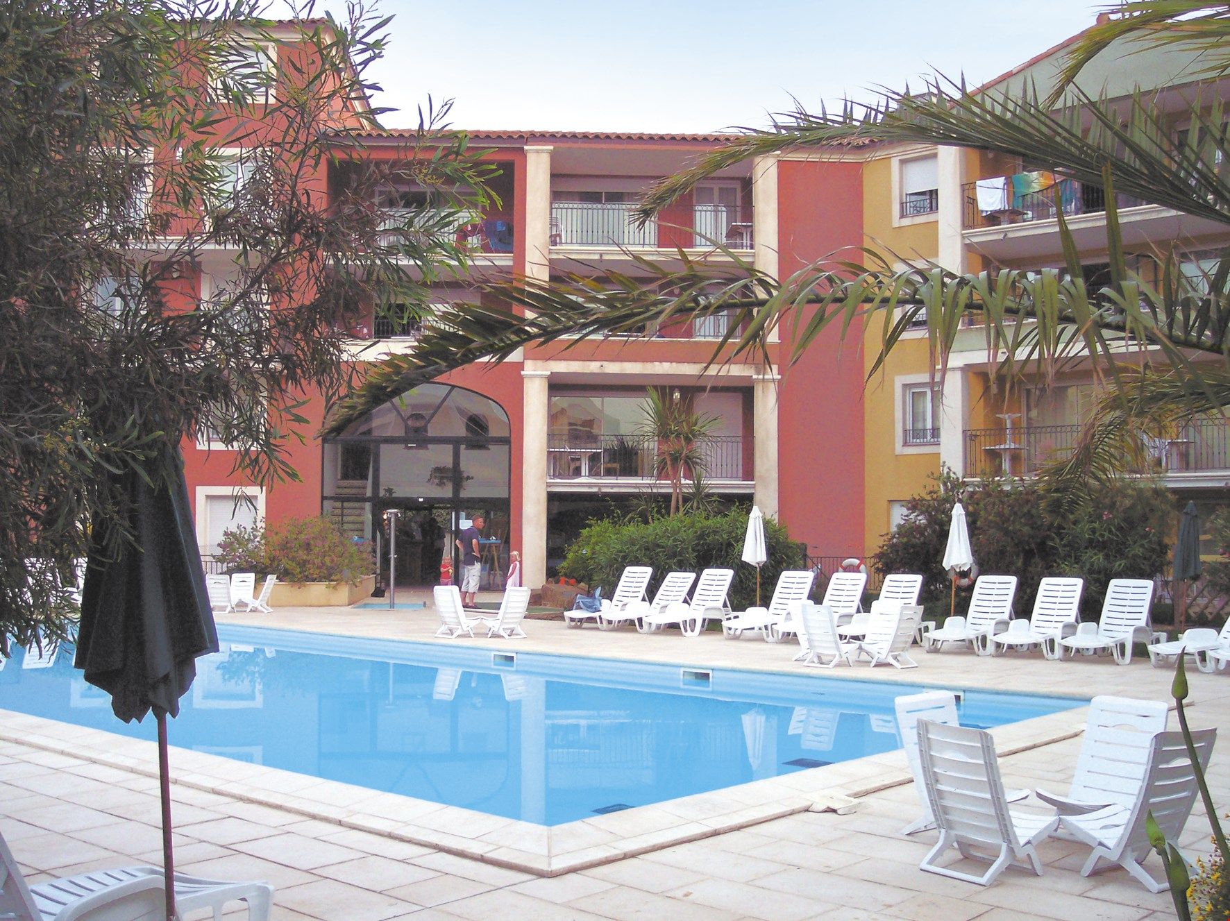 image Relax under the sun around the outdoor swimming pool.