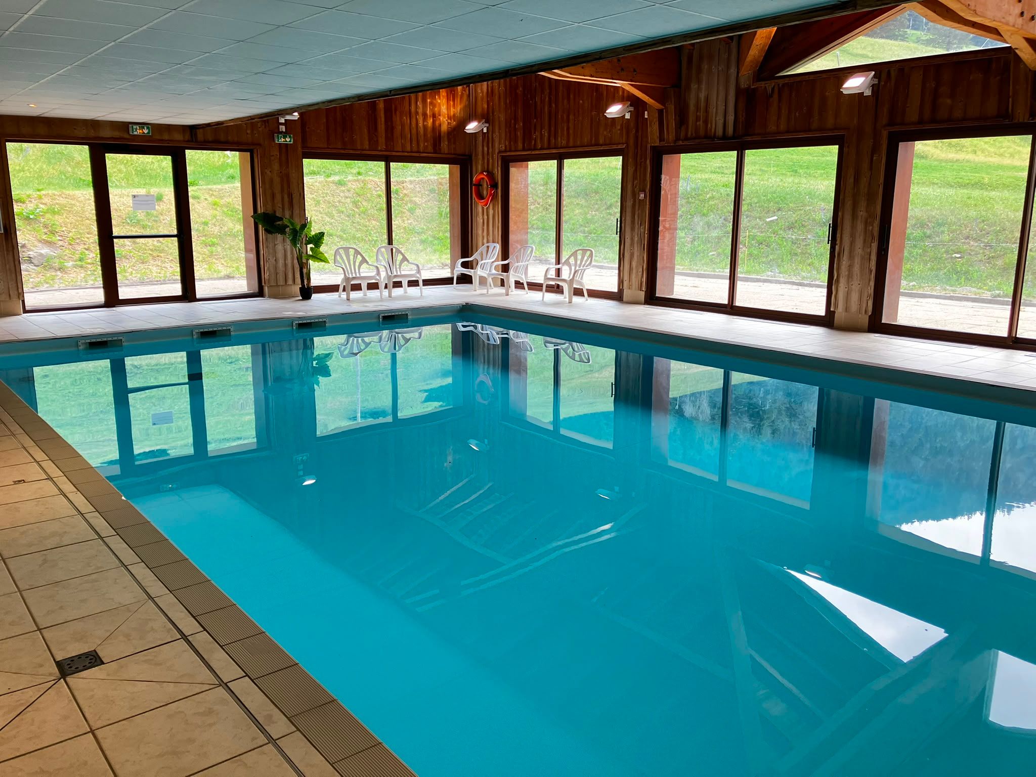 image Wind down poolside, with tall windows framing views of the surrounding greenery and mountains