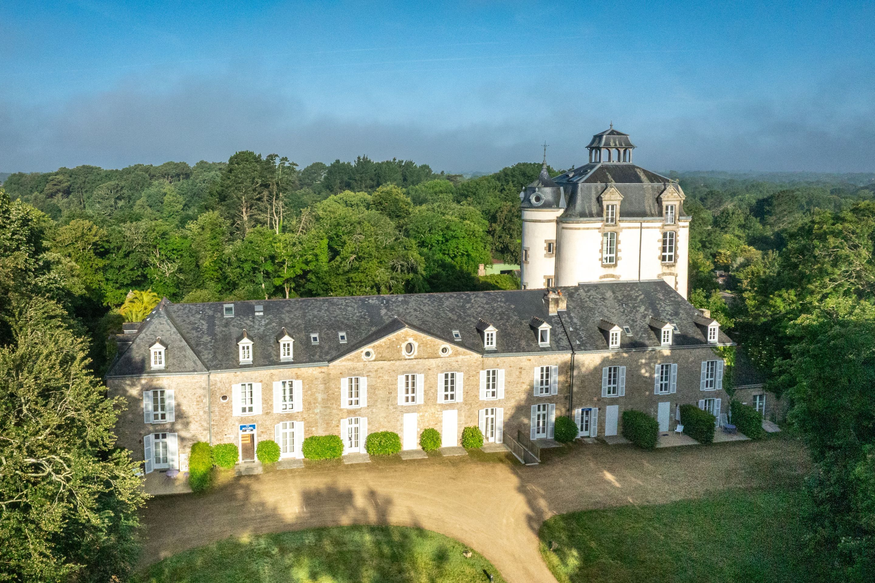 image Seen from above, the tower stands out among the surrounding trees and grassy grounds.
