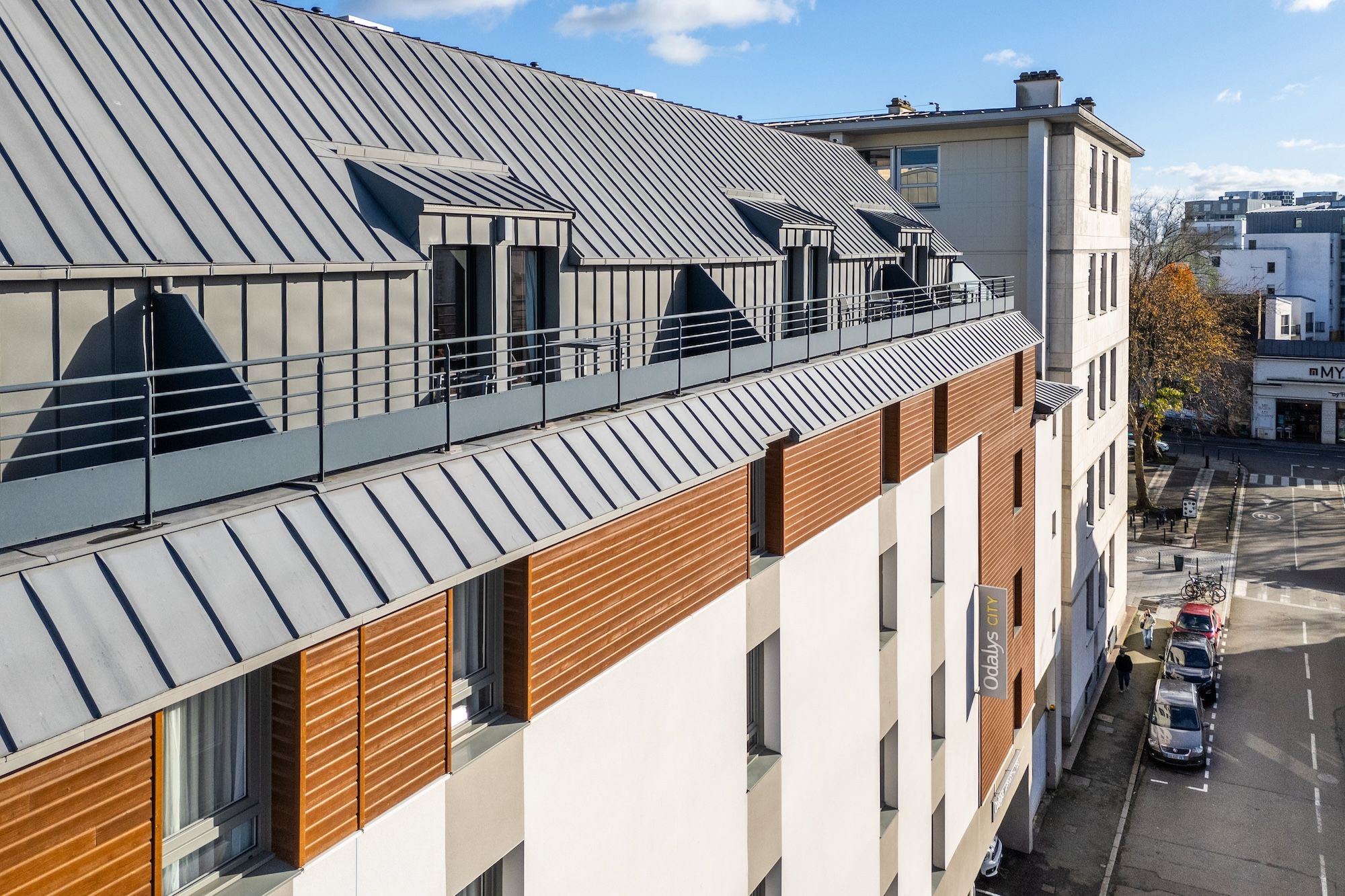 image The exterior showcases a contemporary design with a striking combination of sleek metal roofing and warm wooden panels, inviting guests into a modern space right in the heart of Rennes.
