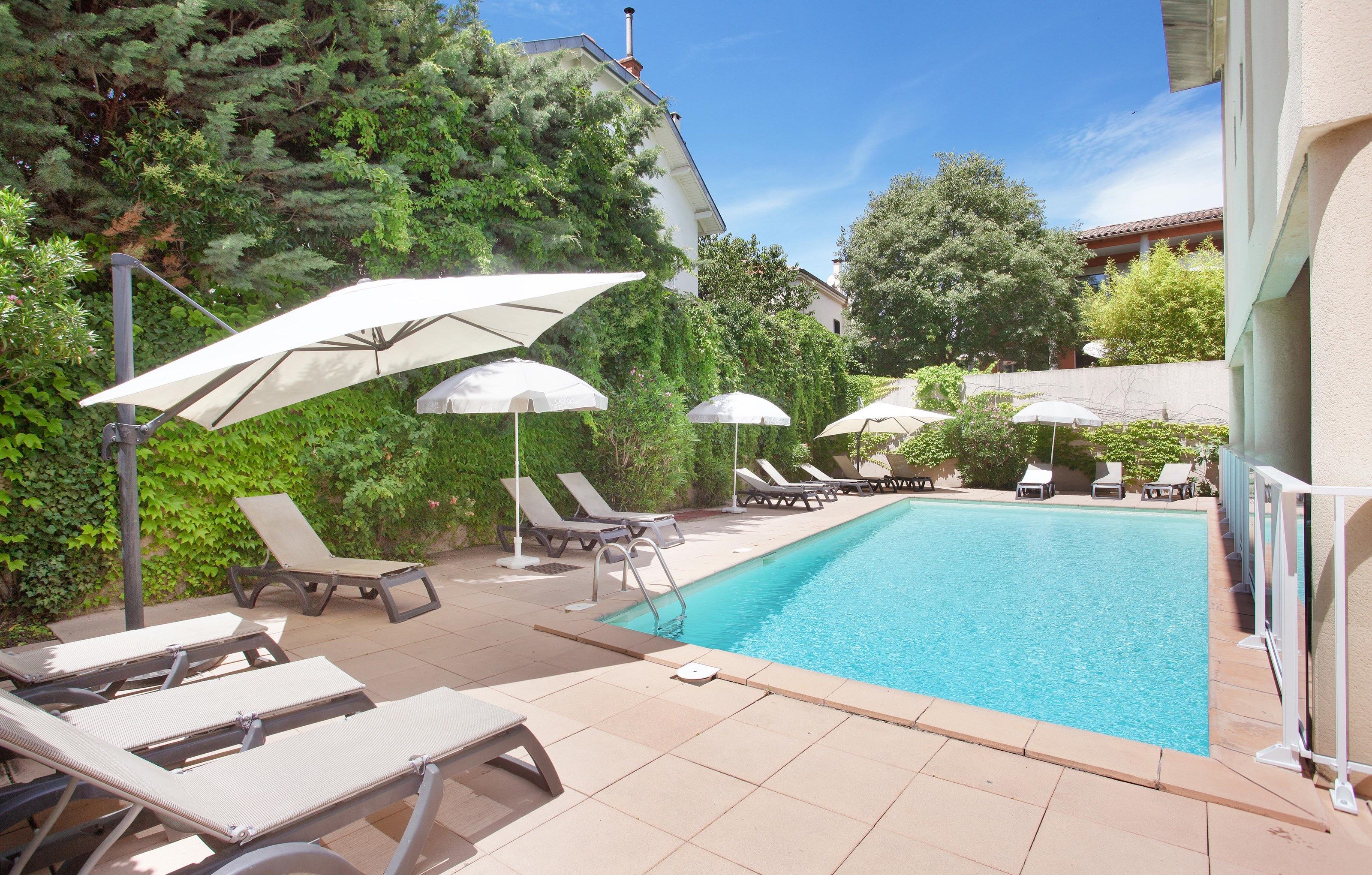 image Enjoy a refreshing dip in the serene outdoor pool, complete with sun loungers for ultimate relaxation.