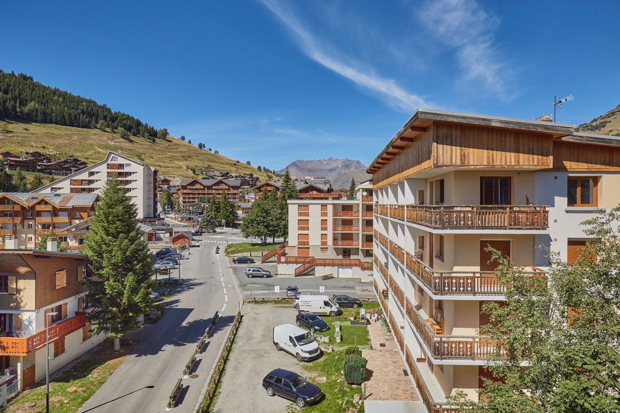 image Street of chalet-style buildings with a forested hillside behind