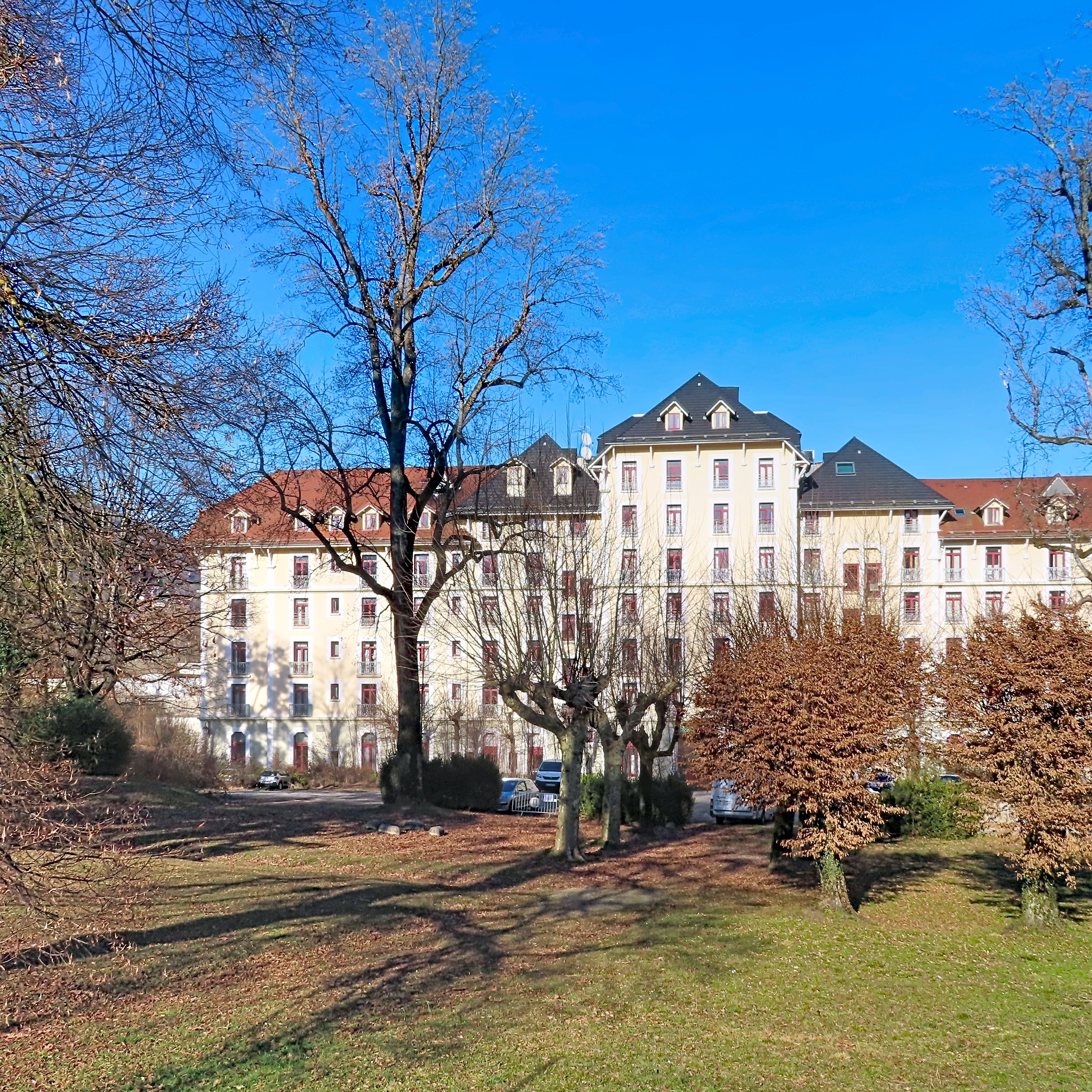 image Residence exterior in early spring, framed by bare trees.