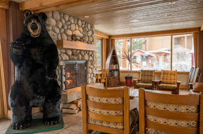 Gather around the magnificent stone fireplace at Hidden Ridge Resort in Banff for cozy evenings.