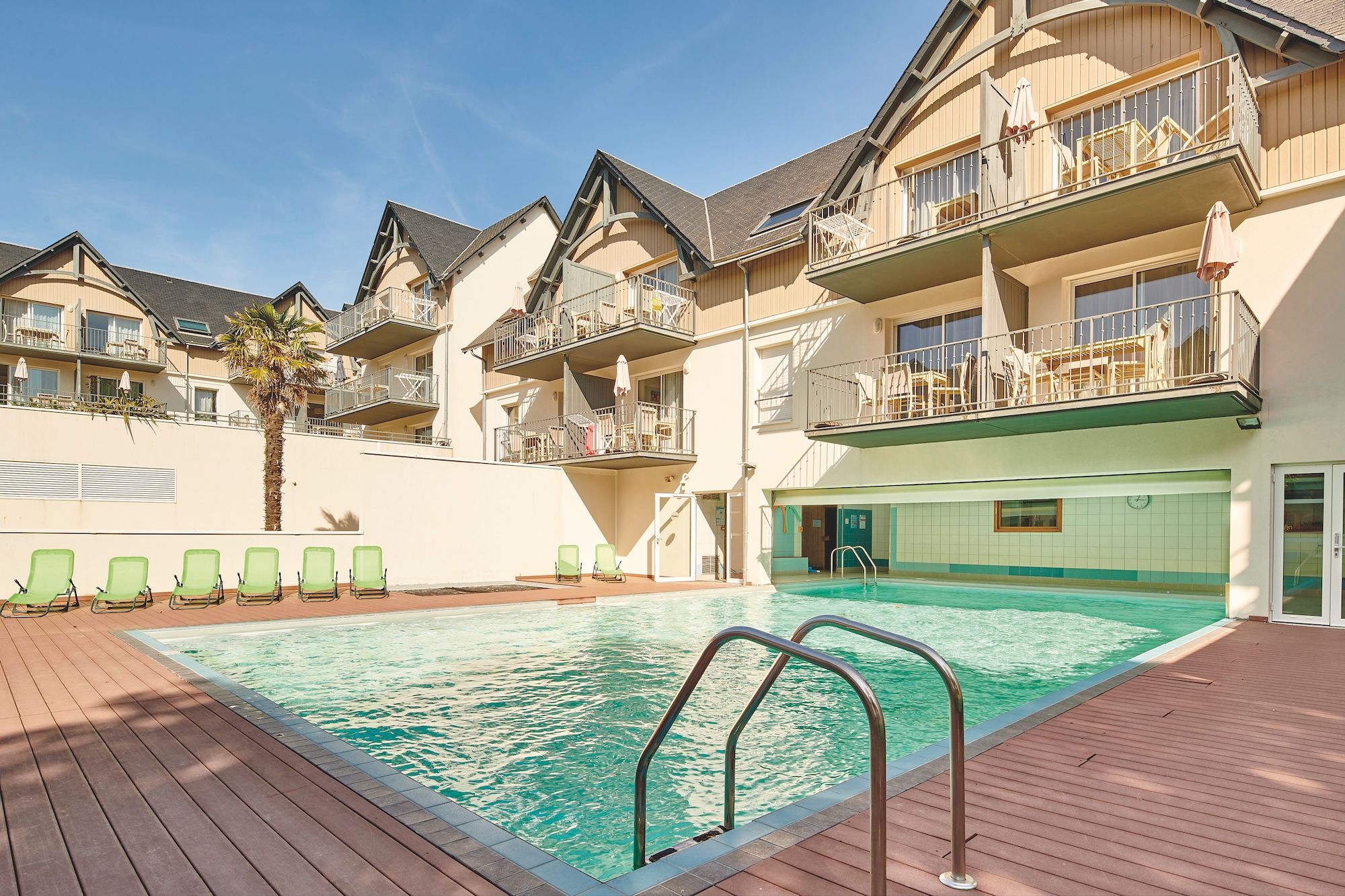image Green loungers line the heated pool, with the apartment balconies rising all around
