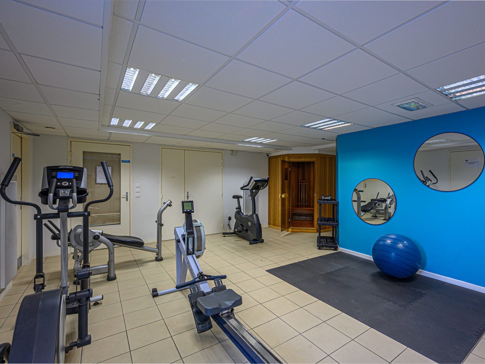 image On-site fitness room with cardio equipment including an elliptical and rowing machine