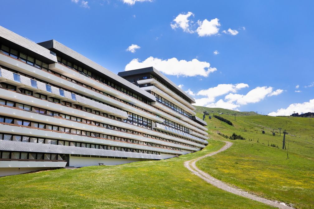image The Le Brelin building in summer, green slopes replacing snow and the mountains just as commanding.
