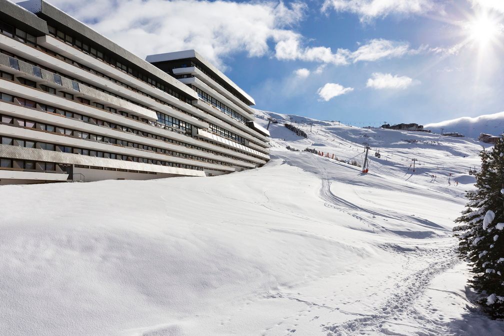 image A sunny winter's day at Le Brelin, balconies overlooking the ski area and lifts ascending into the Trois Vallées.