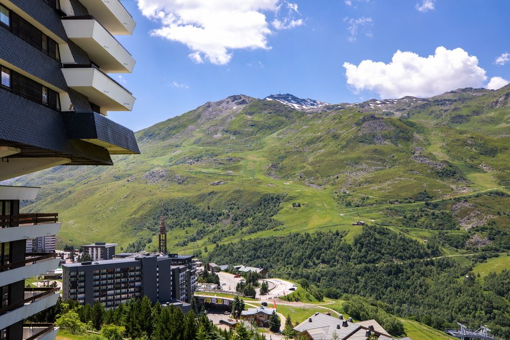 image Wide open alpine meadows with the Savoie peaks stretching behind — summer hiking trails start right from the village.