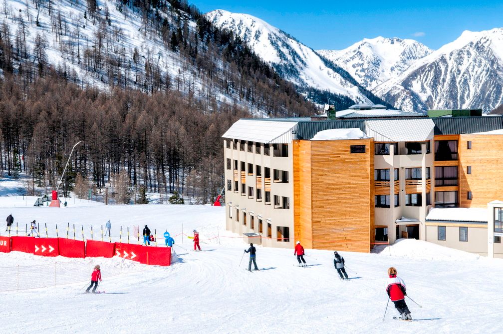 image Skiers passing the building on a clear day — the slopes are literally on the doorstep here.