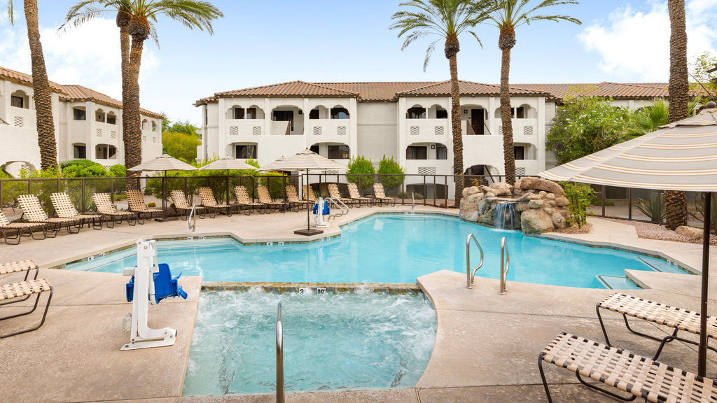 image Unwind in the tranquil pool area, complete with a soothing hot tub and lush landscaping.