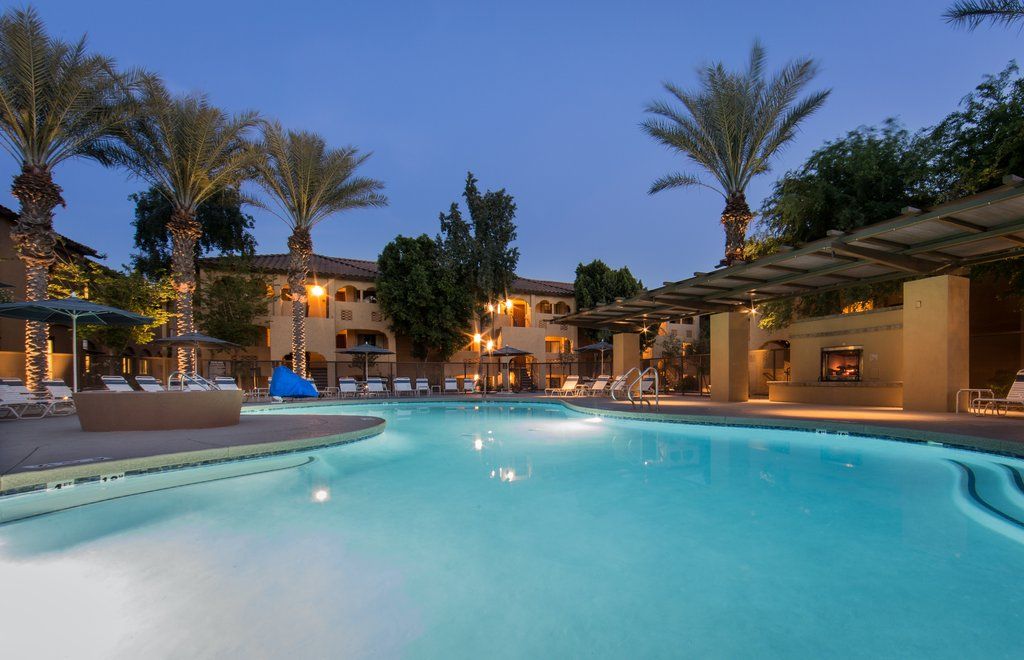 image Relax by the shimmering pool, surrounded by swaying palms and soft evening lights.