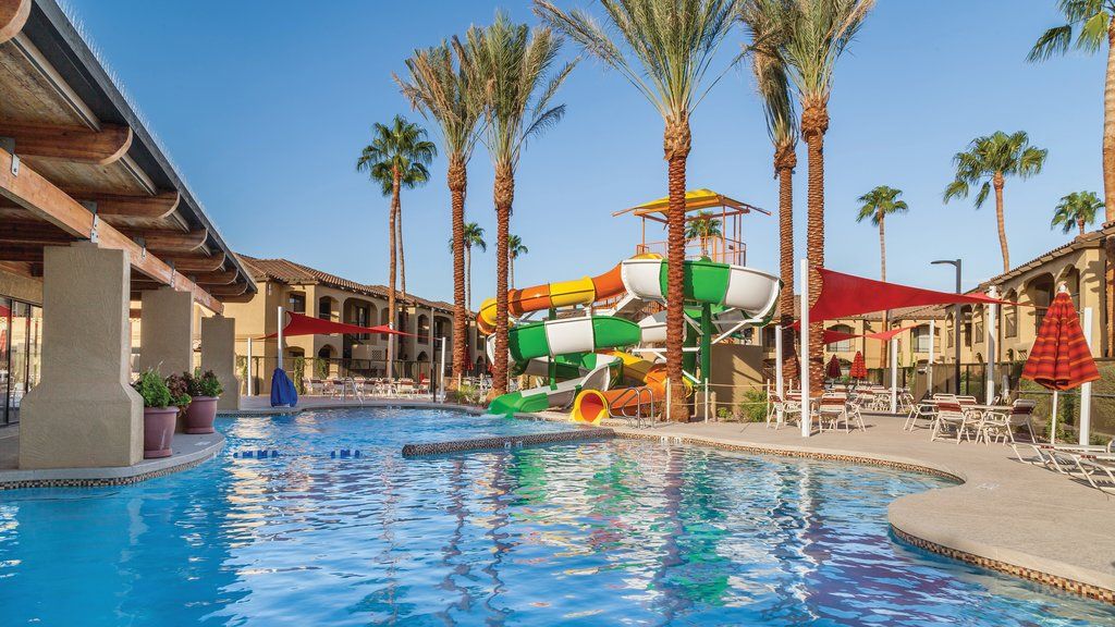 image Splash down the colorful water slides into the refreshing pool surrounded by swaying palm trees.