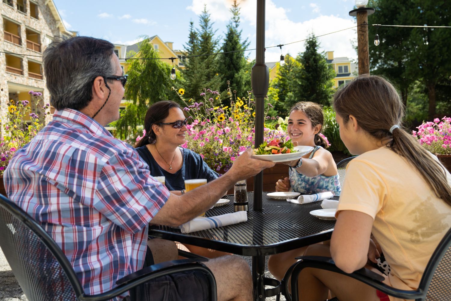 image Guests enjoy alfresco summer dining at Coleman Brook Tavern, surrounded by flowers and mountain views at South Face Village Condominiums.