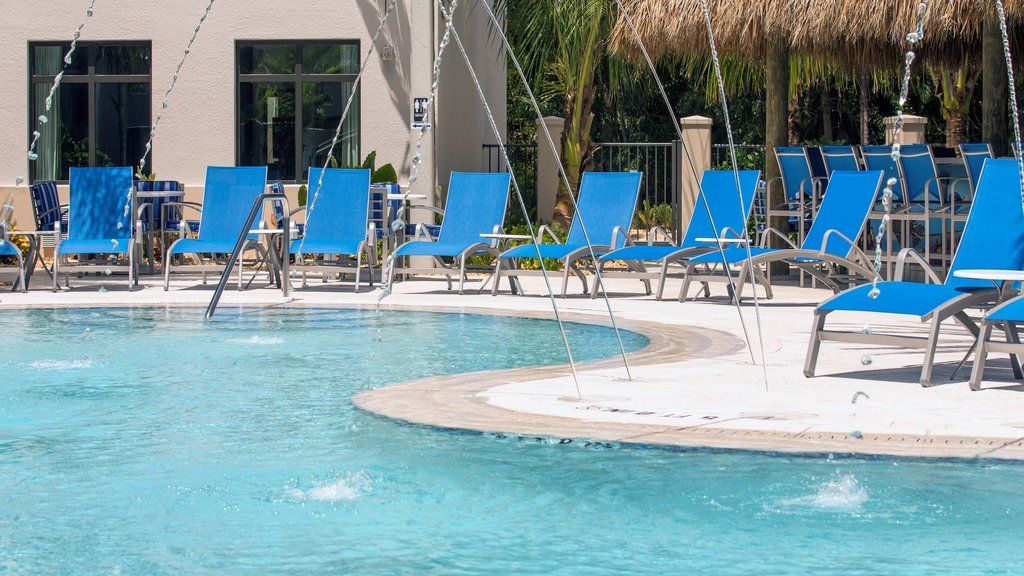 image Relax poolside on vibrant blue loungers, surrounded by a refreshing aquatic oasis.