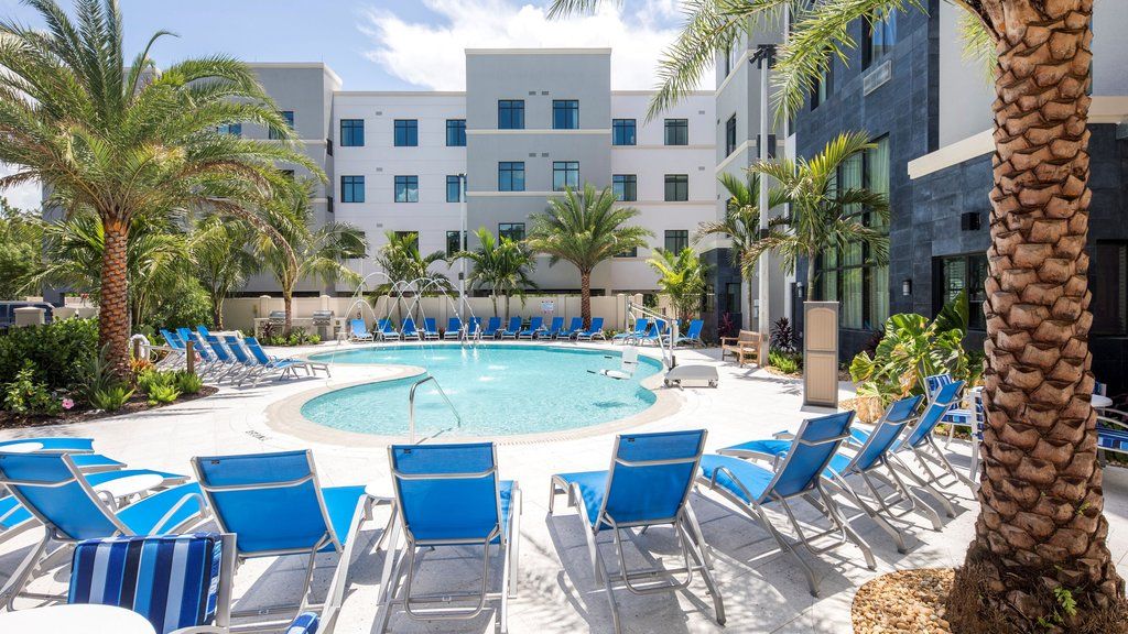 image Bask in the sun by the sparkling pool, surrounded by swaying palm trees and comfortable lounge chairs.