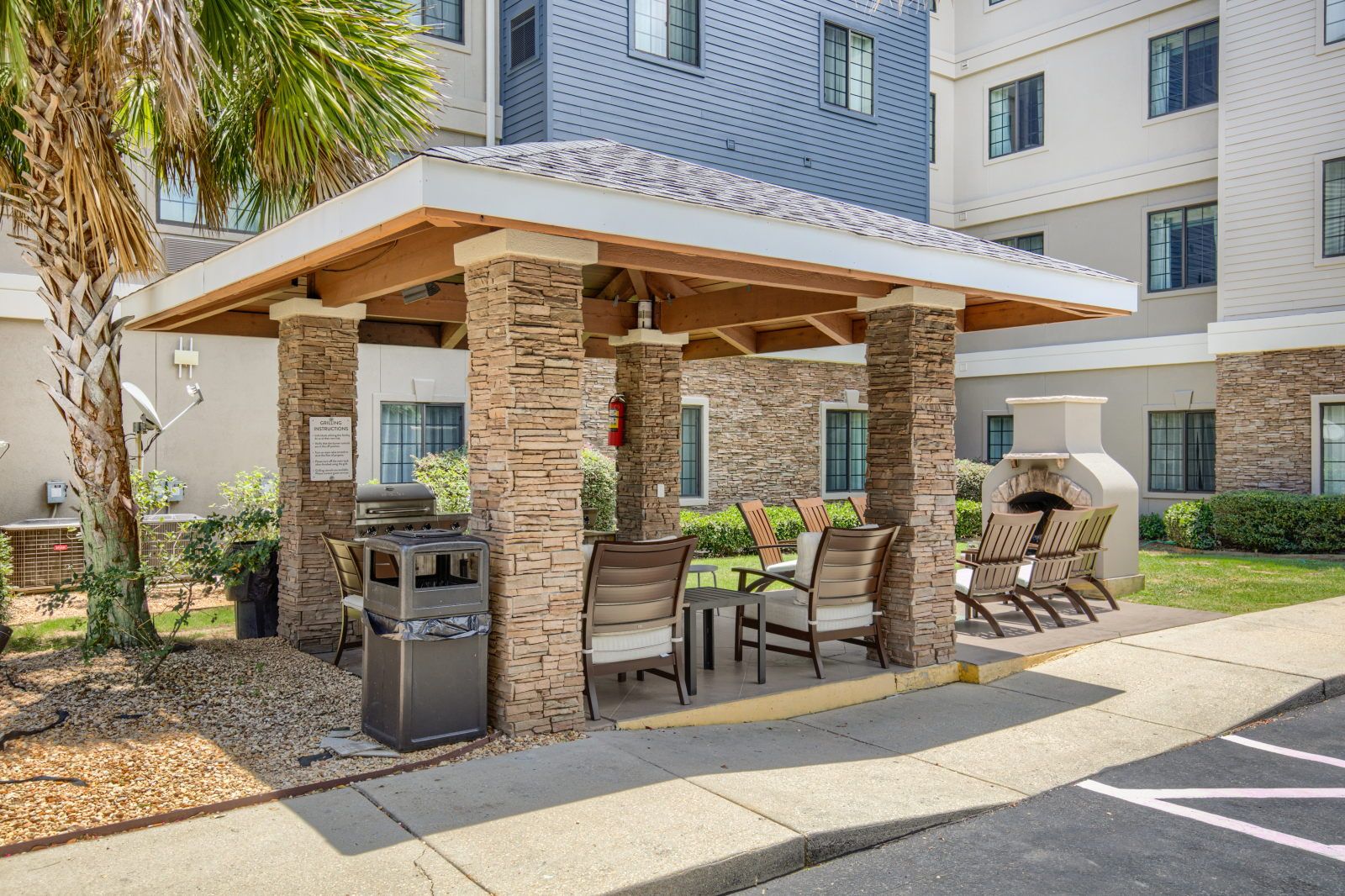 image Covered outdoor BBQ pavilion with stone columns and seating
