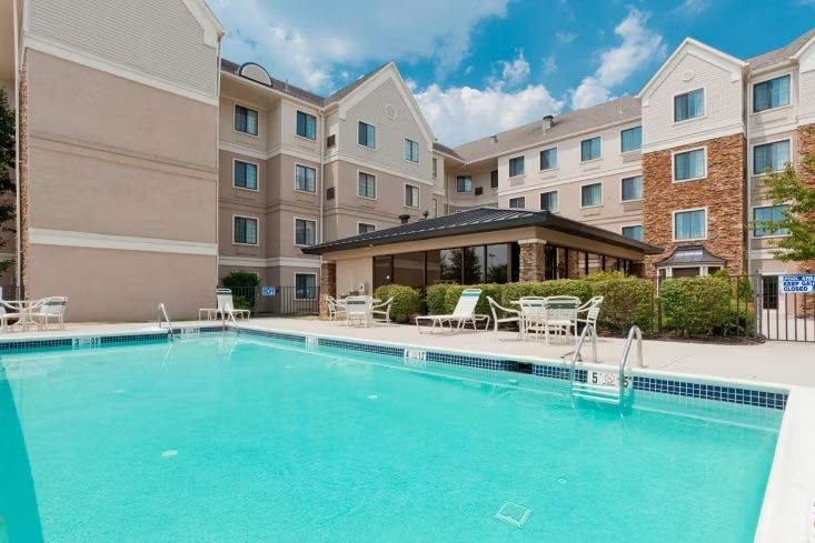 image Outdoor swimming pool with lounge chairs on deck.