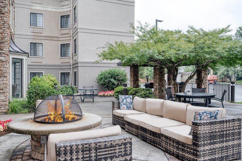image Shaded patio seating area with chairs and small tables near the courtyard entrance