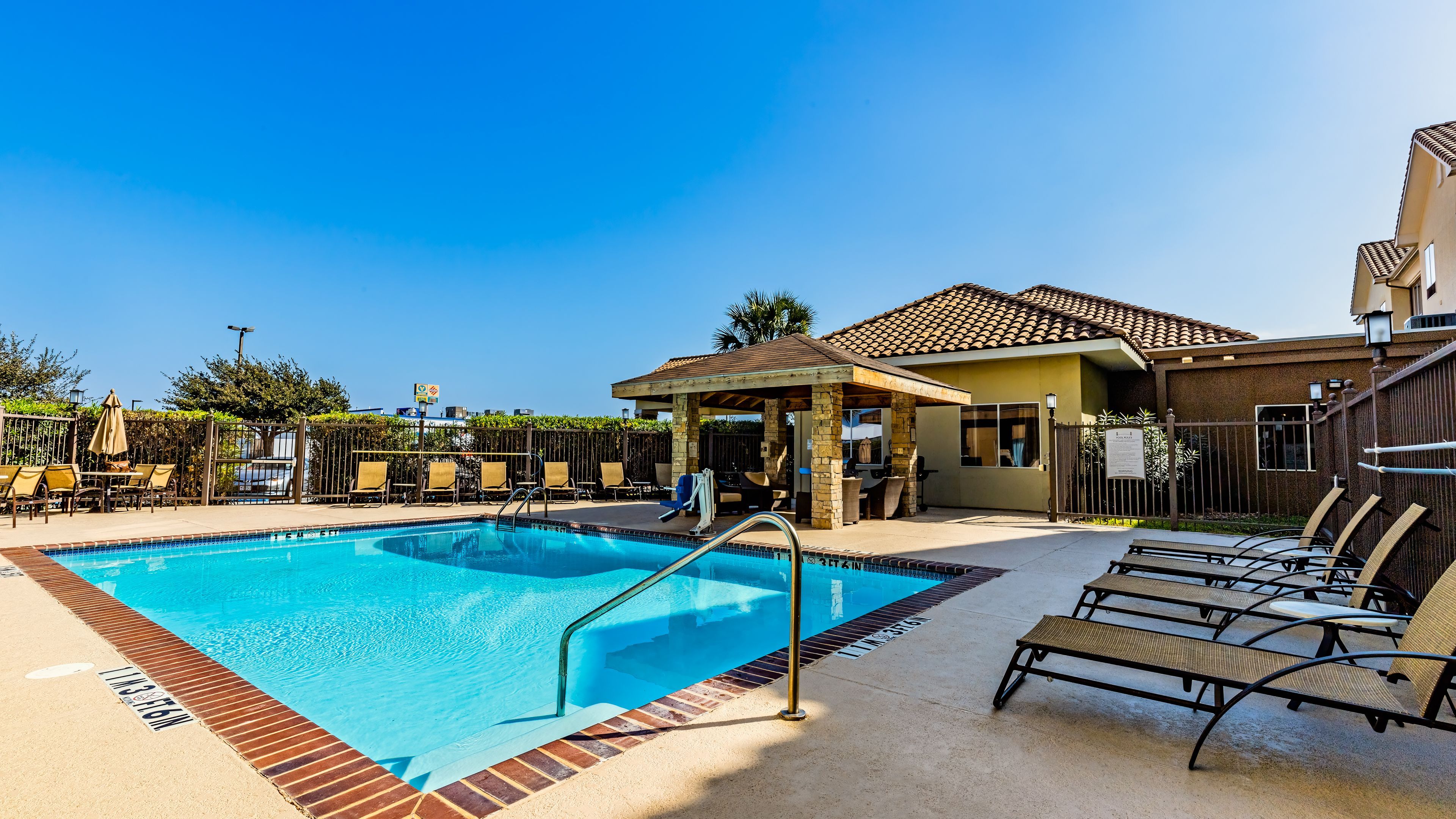 image Take a dip in the outdoor pool lined with sun loungers and shaded seating