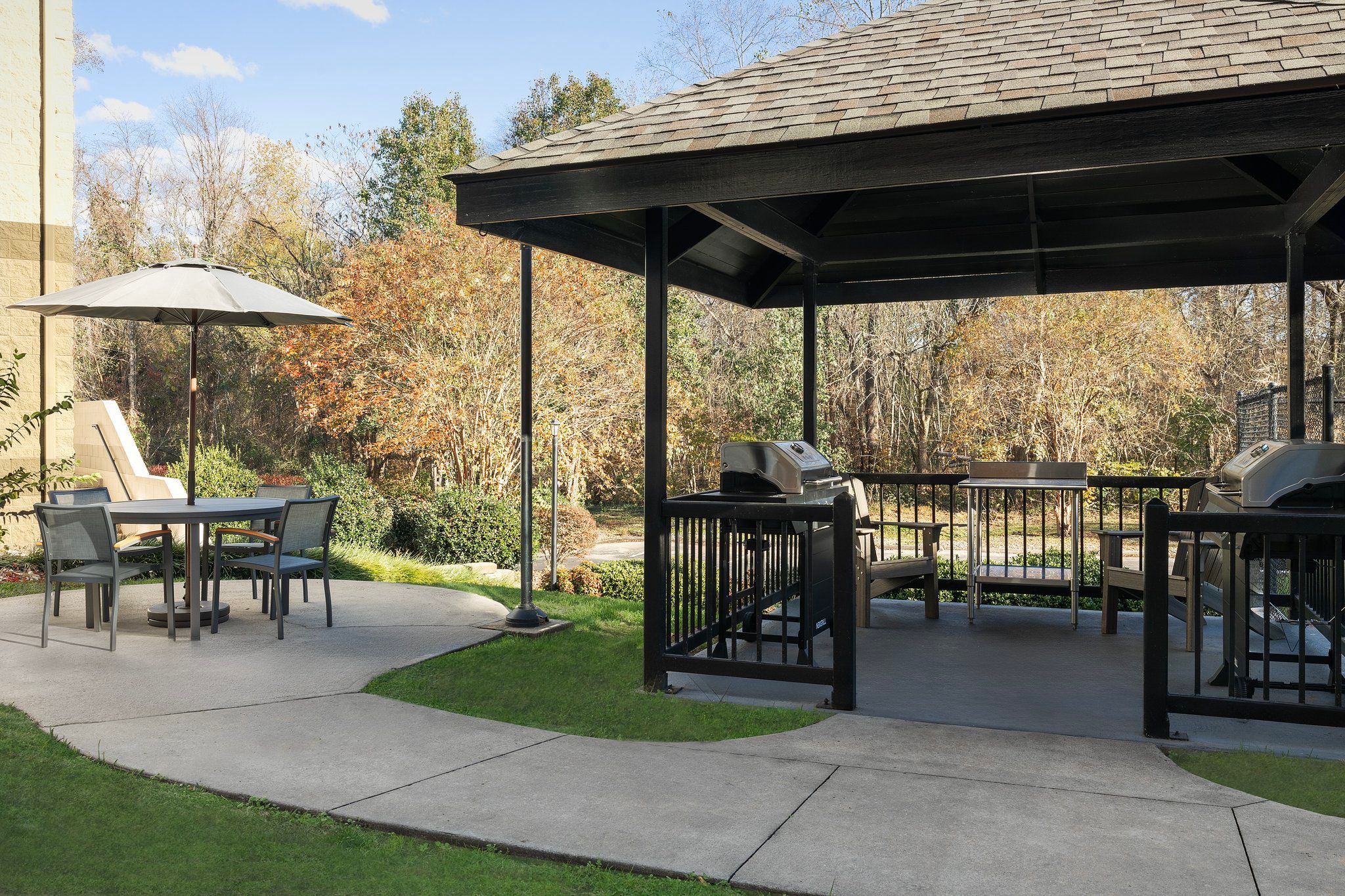 image Gather around the grill in the shaded gazebo, a great spot for outdoor meals surrounded by nature.