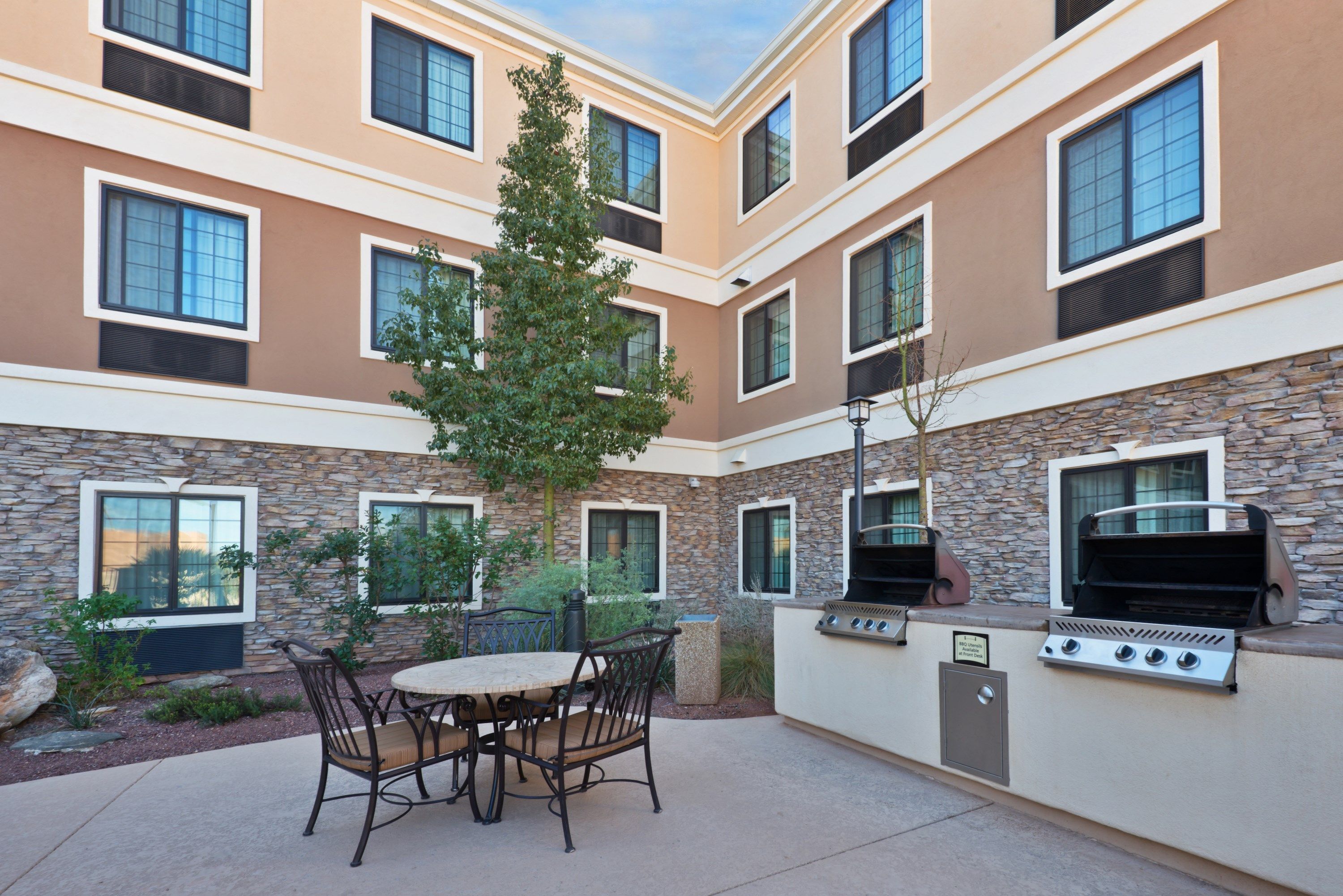 image Outdoor courtyard with guest seating and BBQ grills.