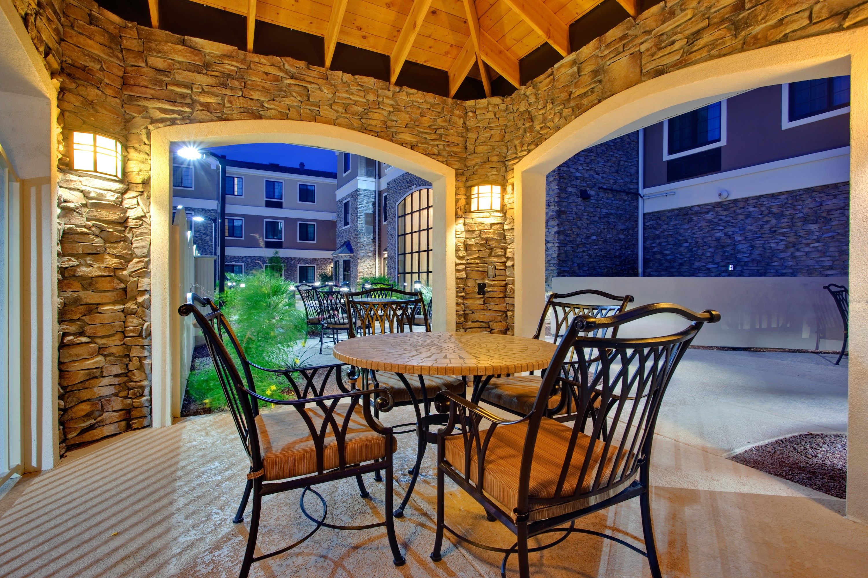 image Outdoor patio with stone archway and guest seating.
