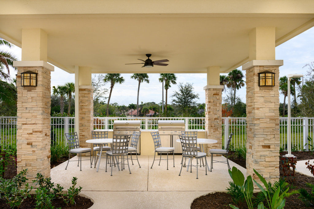image An inviting outdoor grill area offers a great space for barbecues, surrounded by palm trees and a fenced garden for privacy.