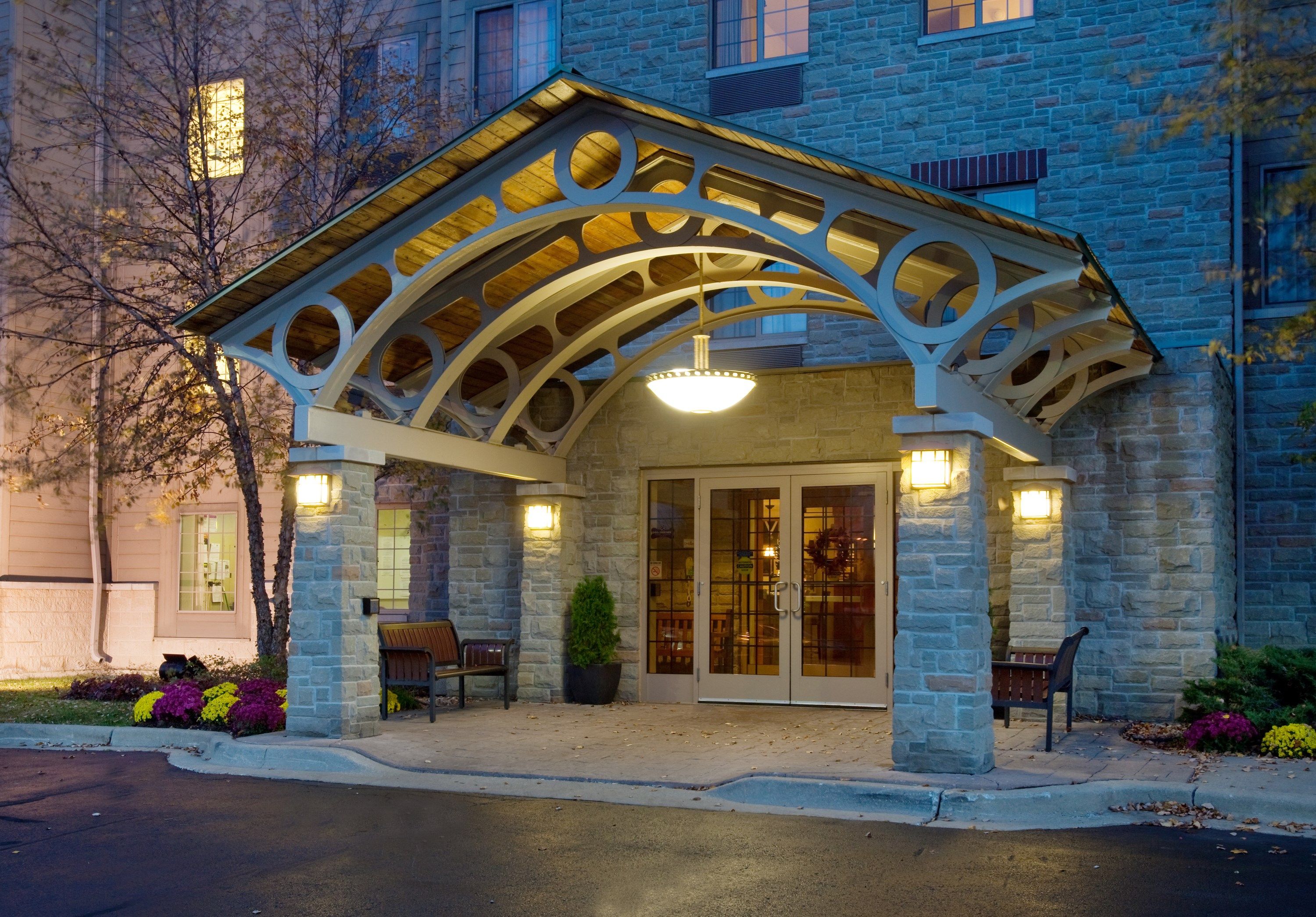 image Hotel entrance canopy with decorative lighting and benches.