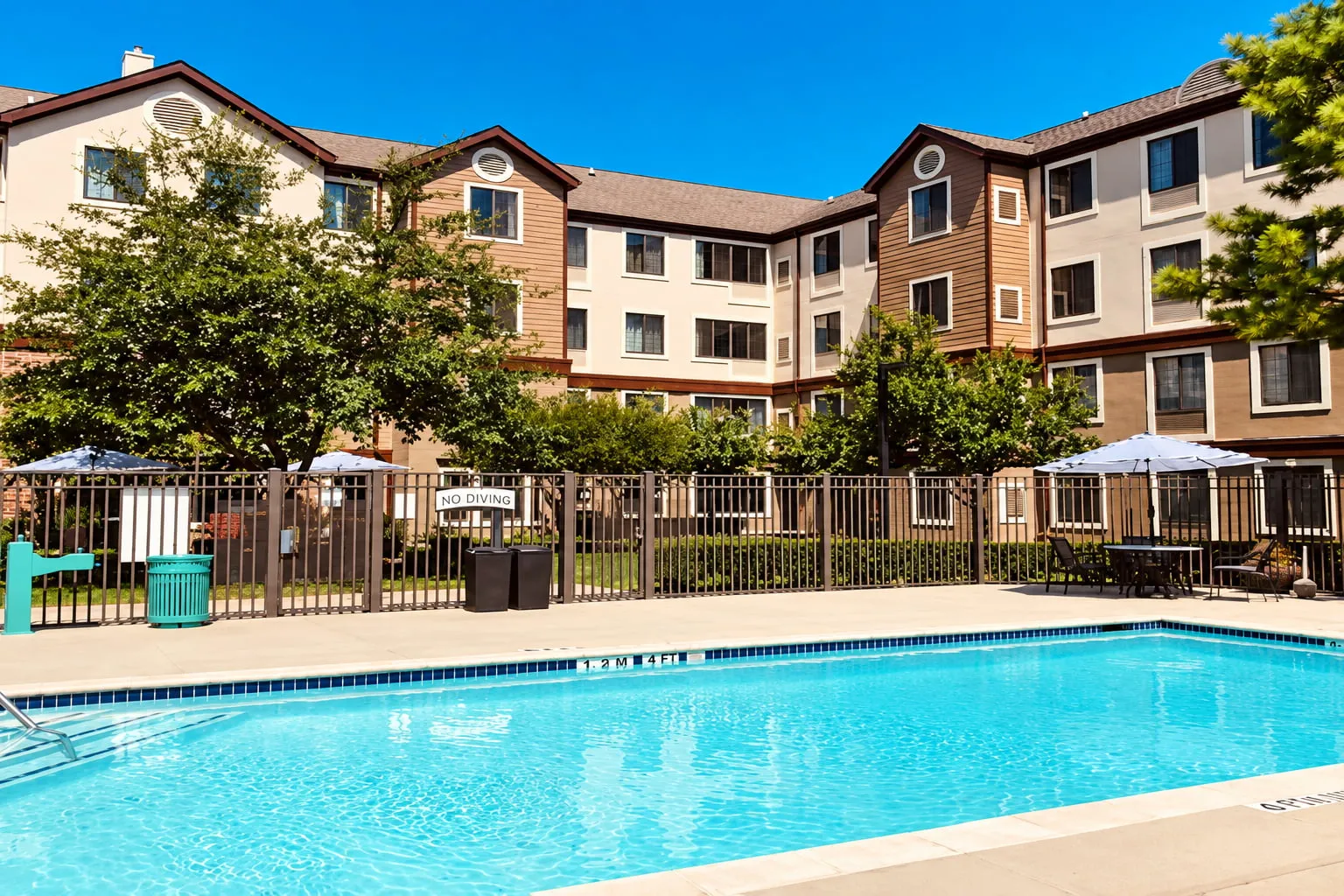 image Pool area surrounded by building and lounge seating.
