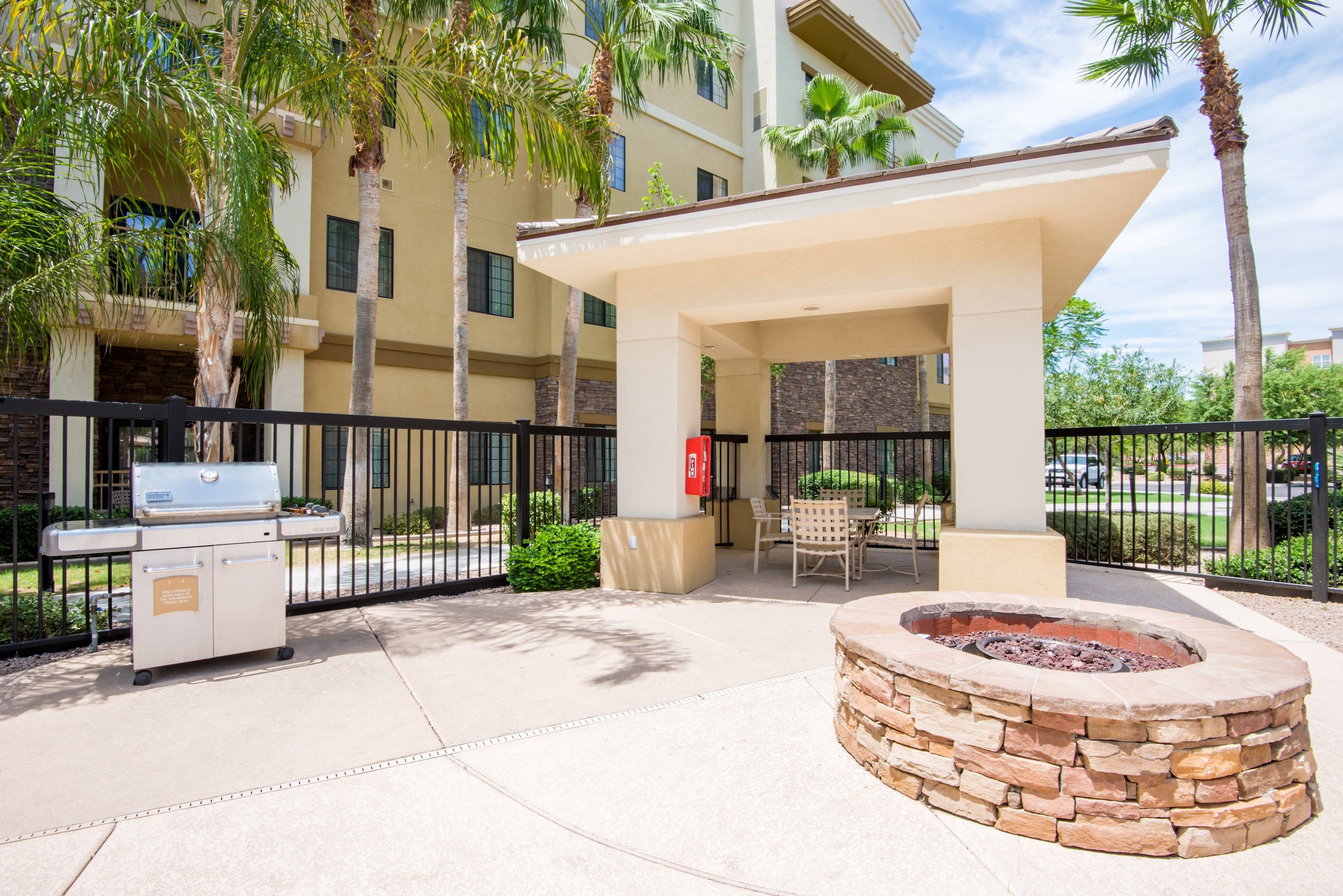 image Outdoor grilling area with a fire pit and seating.